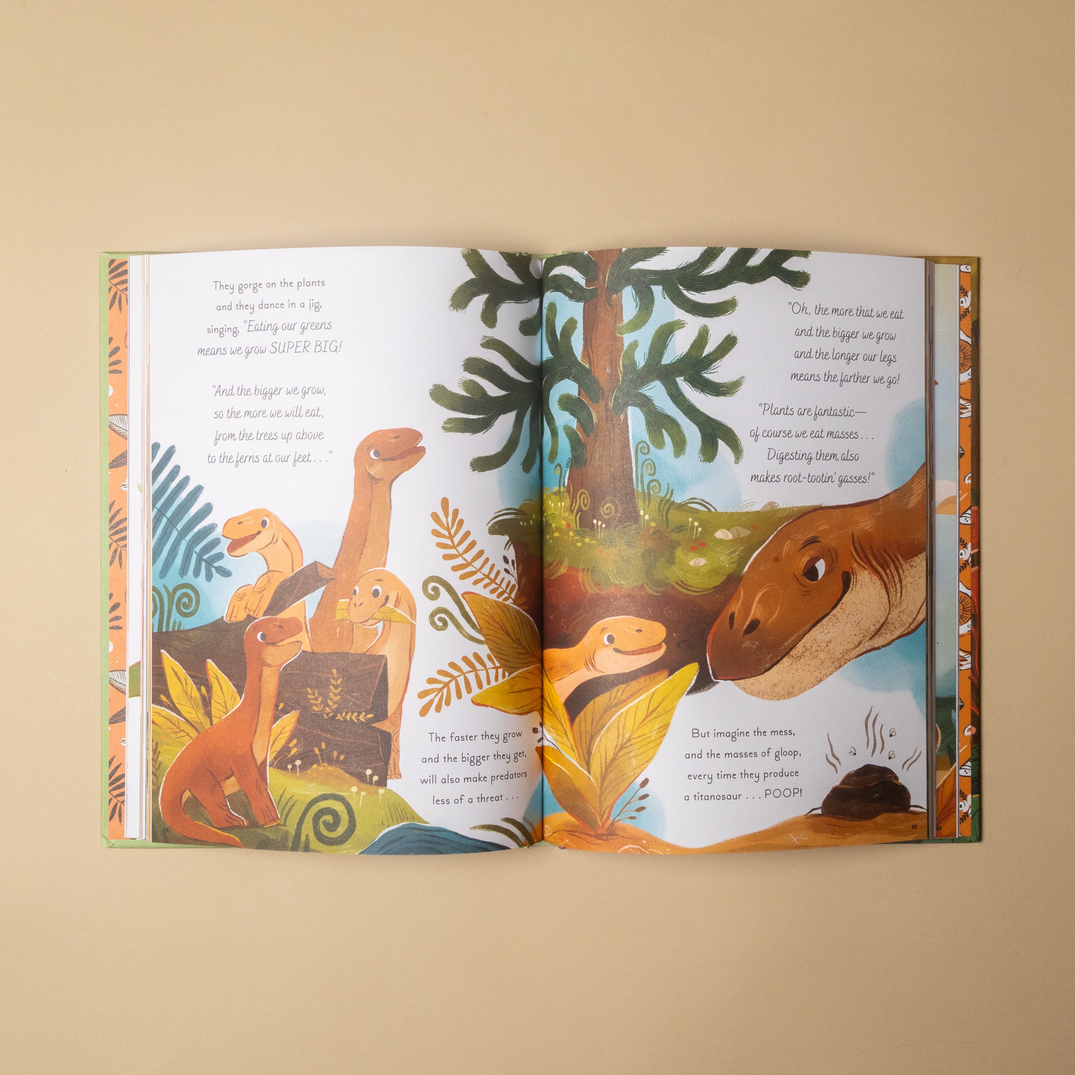An open children's picture book showing dinosaur-themed illustrated pages on a warm beige background. The book has colorful dinosaur drawings and text, photographed from above at a slight angle.