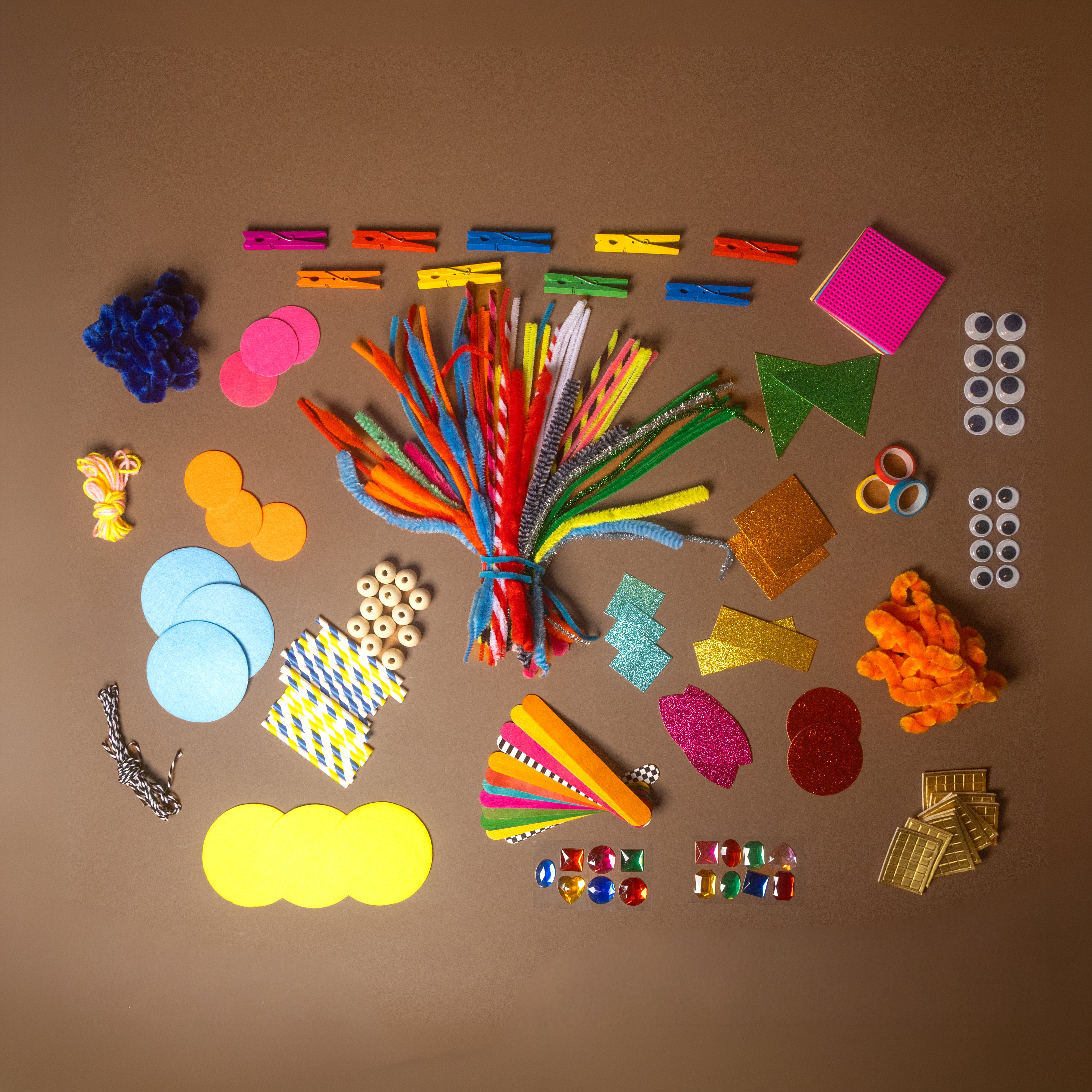 My-First-Arts-_-Crafts-Library Assorted craft supplies including foam shapes, ribbons, and other decorative items on a brown background