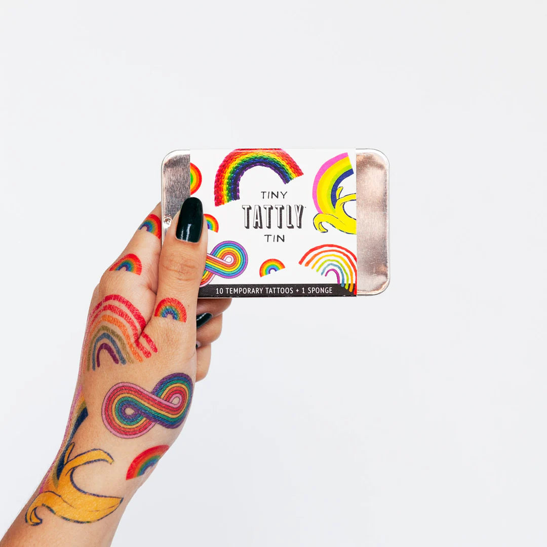Tiny-Tattly-Tin-Rainbow Hand with temporary tattoos holding a Tiny Tattly Tin with rainbow designs.