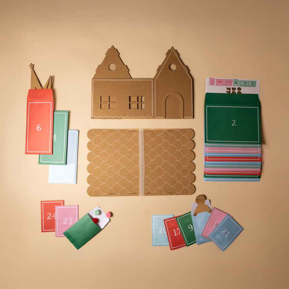 advent-calendar-play-kit-sticky-gingerbread-Cardboard house model with numbered cards on a beige background