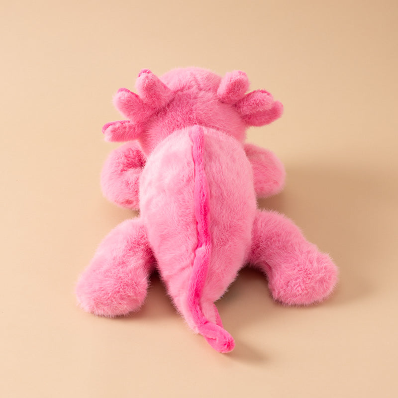 A pink andy-the-axolotyl-kiddo plush toy with a fuzzy, soft texture, featuring small black bead eyes tail