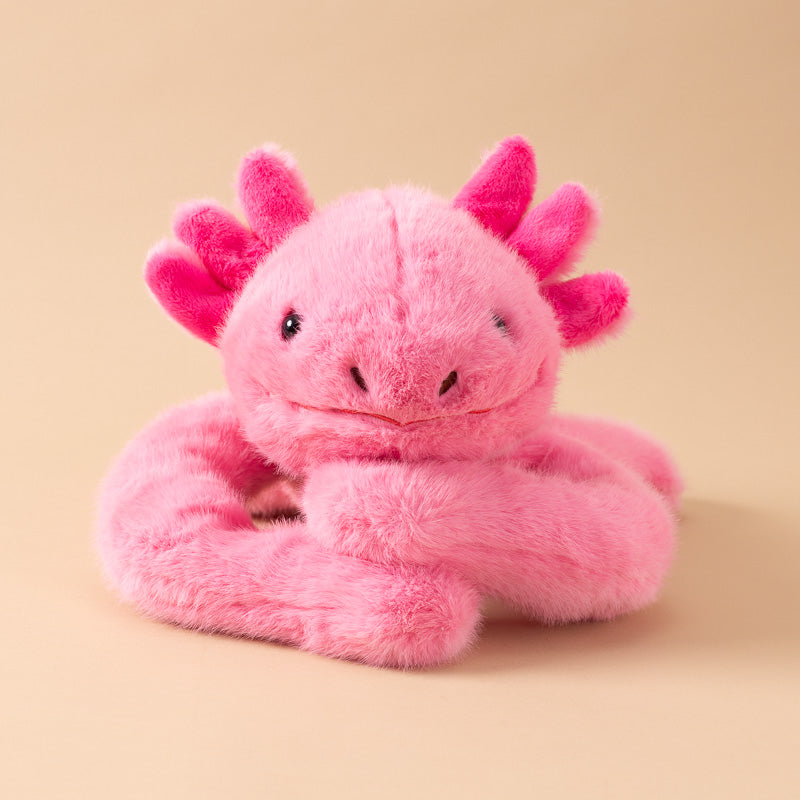 A pink andy-the-axolotyl-kiddo plush toy with a fuzzy, soft texture, featuring small black bead eyes