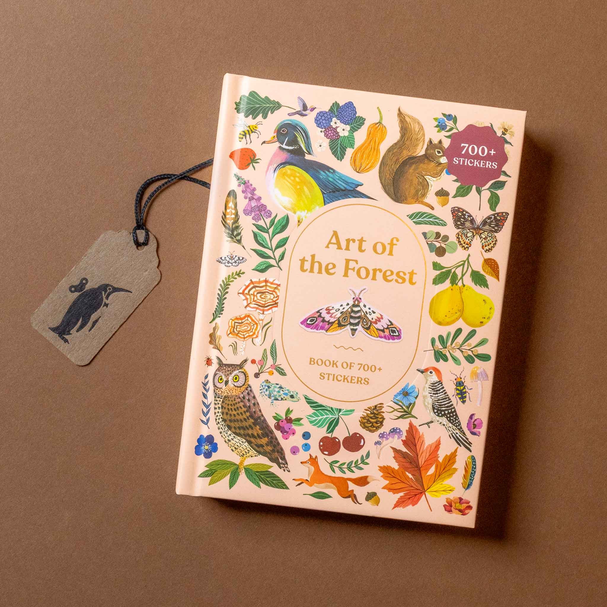 Book titled 'Art of the Forest' with stickers on a brown background