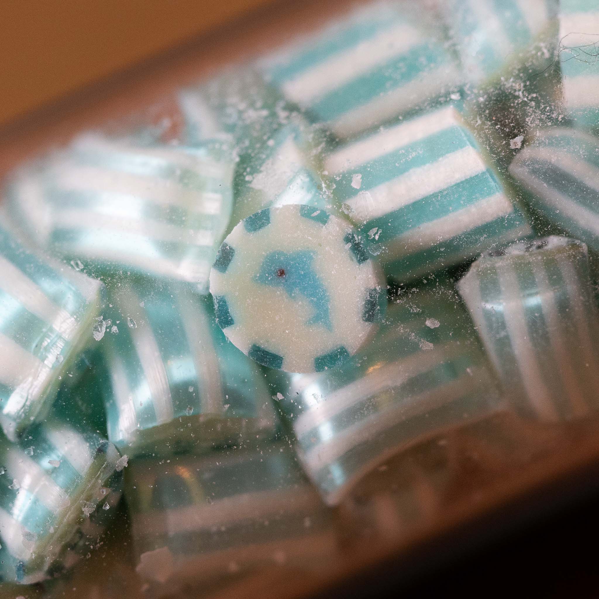 artisanal-hard-candy-tube-blueberry-dolphin Close-up of blue and white striped candies with a clear wrapper.