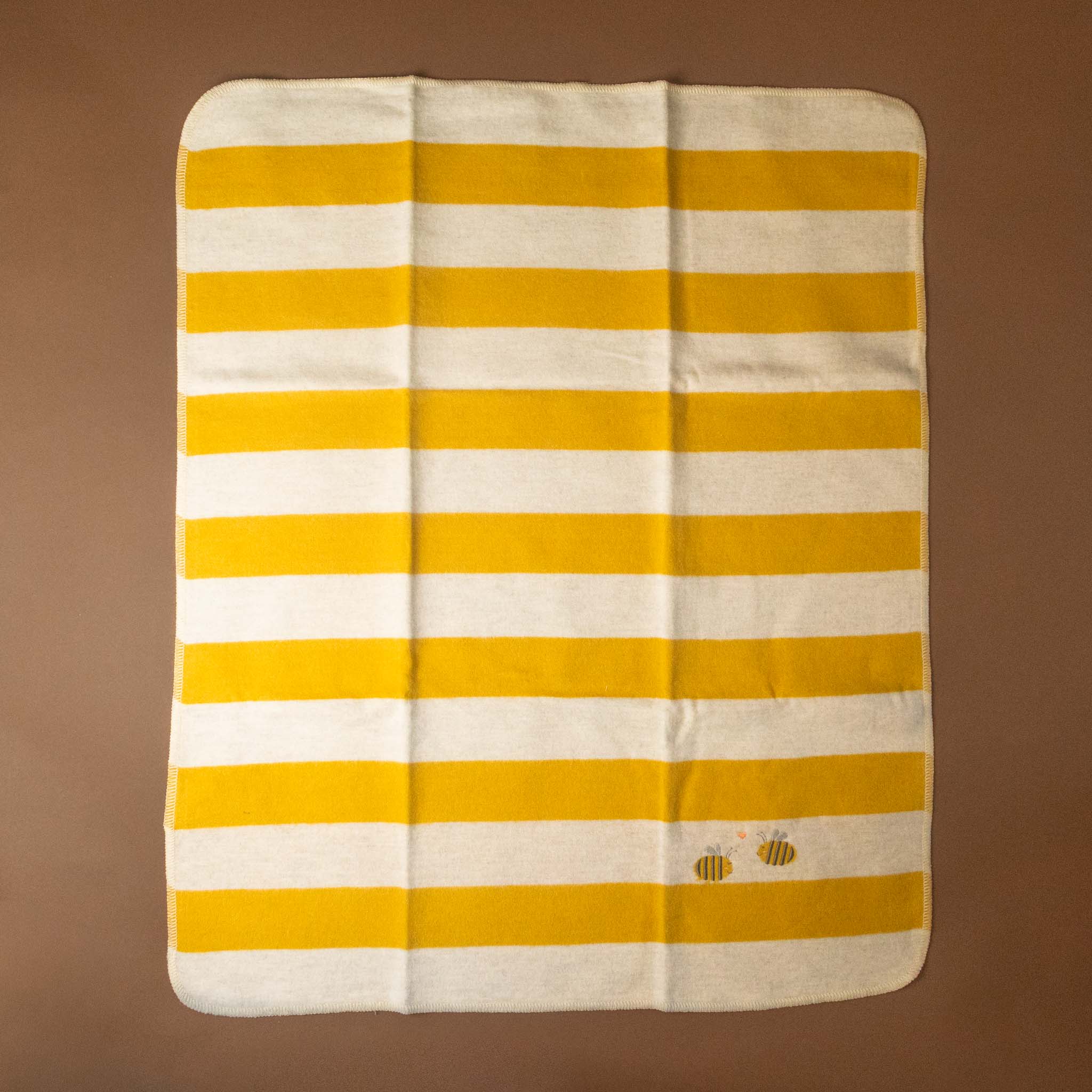 Striped yellow and white baby-blanket-embroidered-bumblebee with a bee logo on a brown background