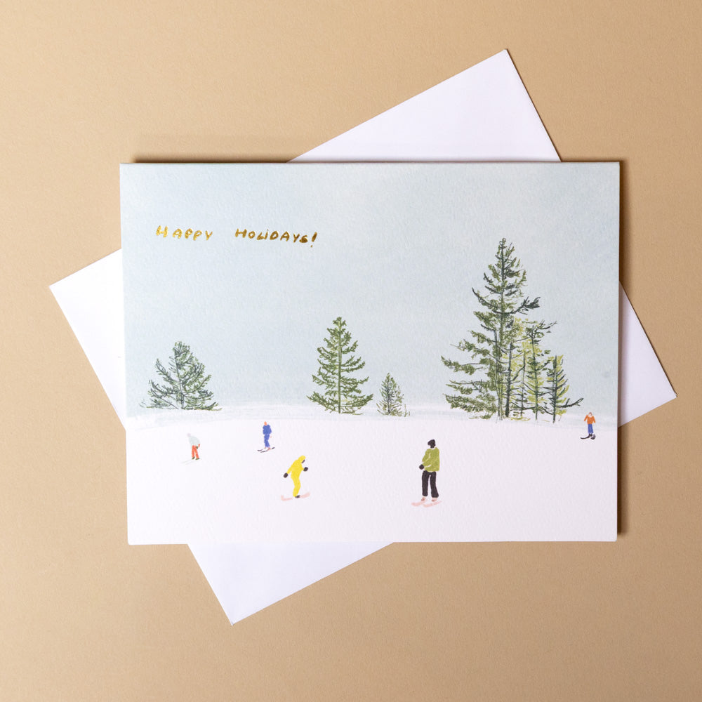 boxed-note-card-set-winter-activities with winter scene and 'Happy Holidays!' text, placed on a beige background.