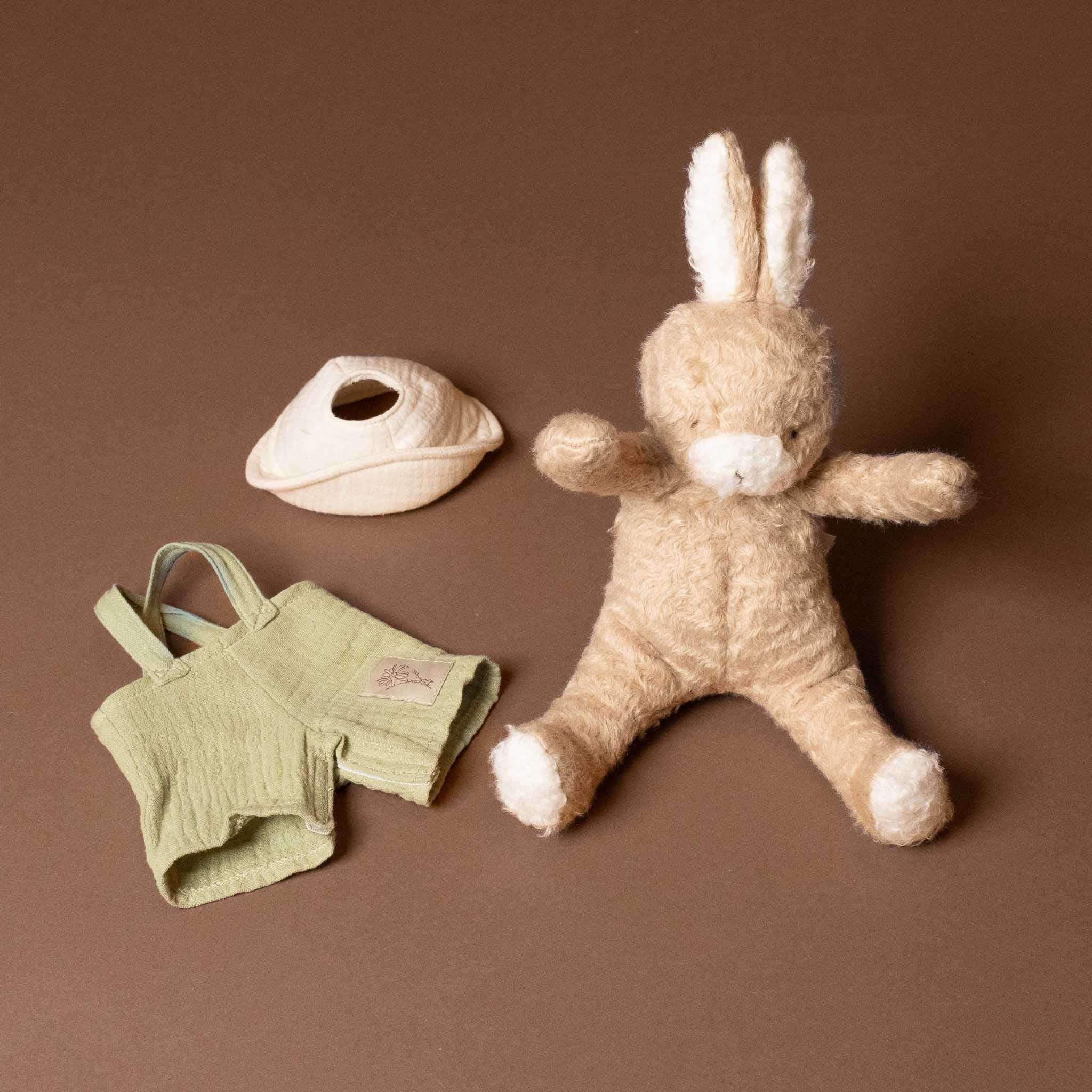 Stuffed bramble-the-bunny-limited-edition with green overalls and white hat on a brown background