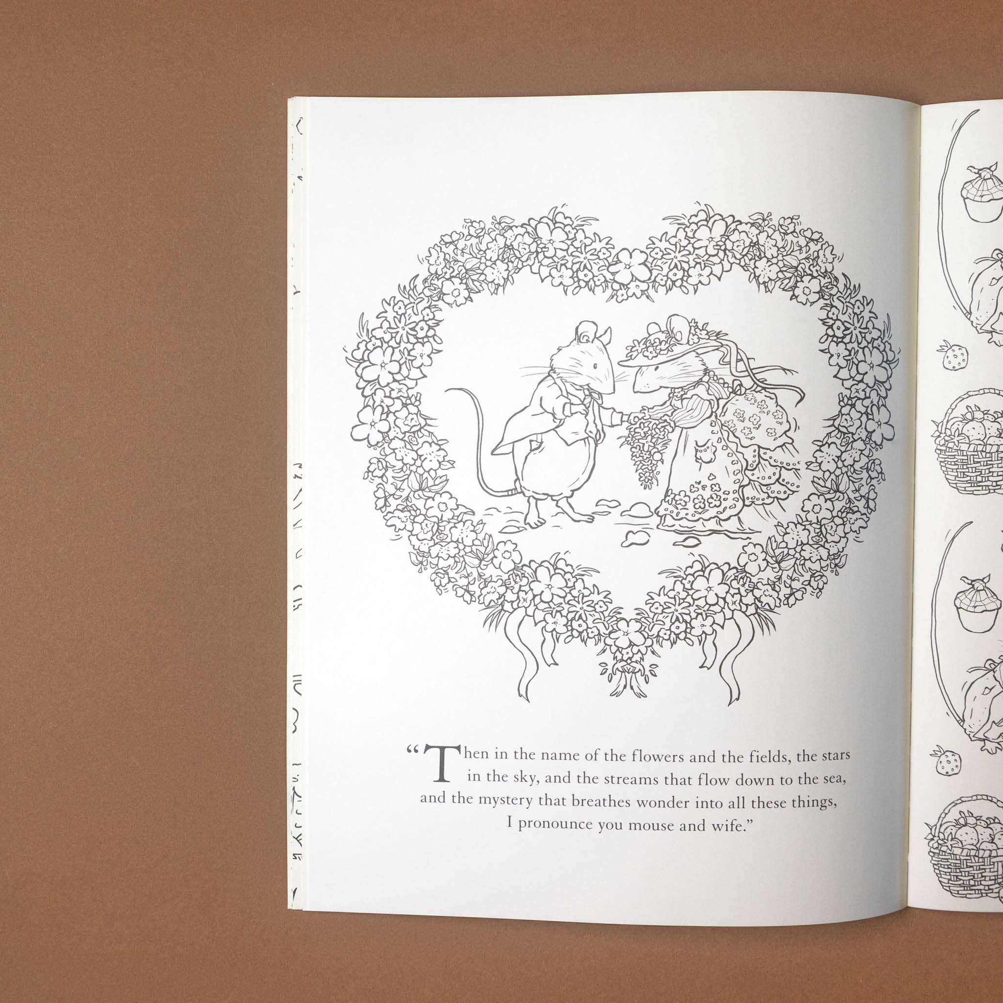 brambly-hedge-nature-coloring-book Open book with a black and white illustration of two mice in a heart-shaped wreath on a brown background.
