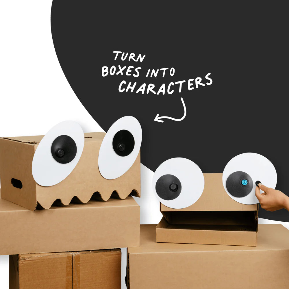 Cardboard boxes with googly eyes and a hand holding a small device, with text 'Turn boxes into characters'.