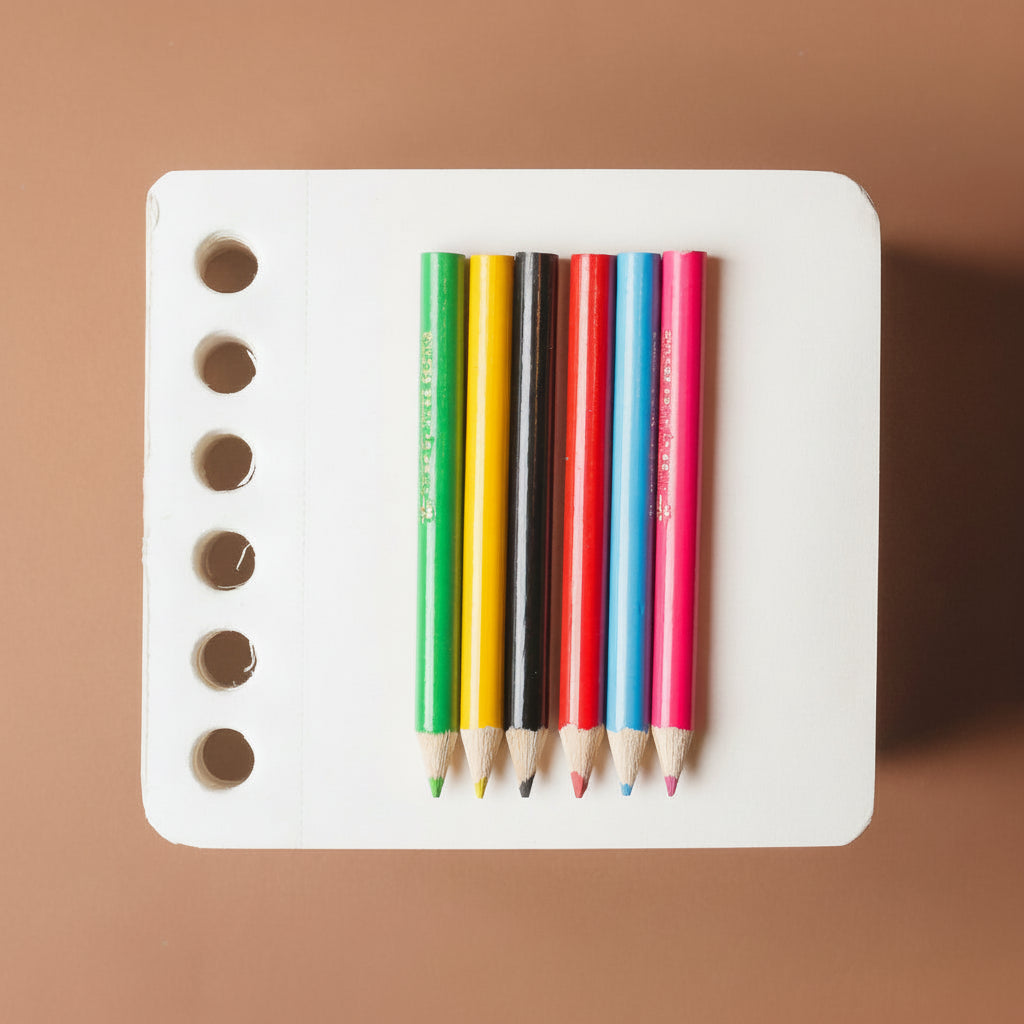 chunky-jotblock-sketch-pad-squared White cube with colorful pencils on a brown background