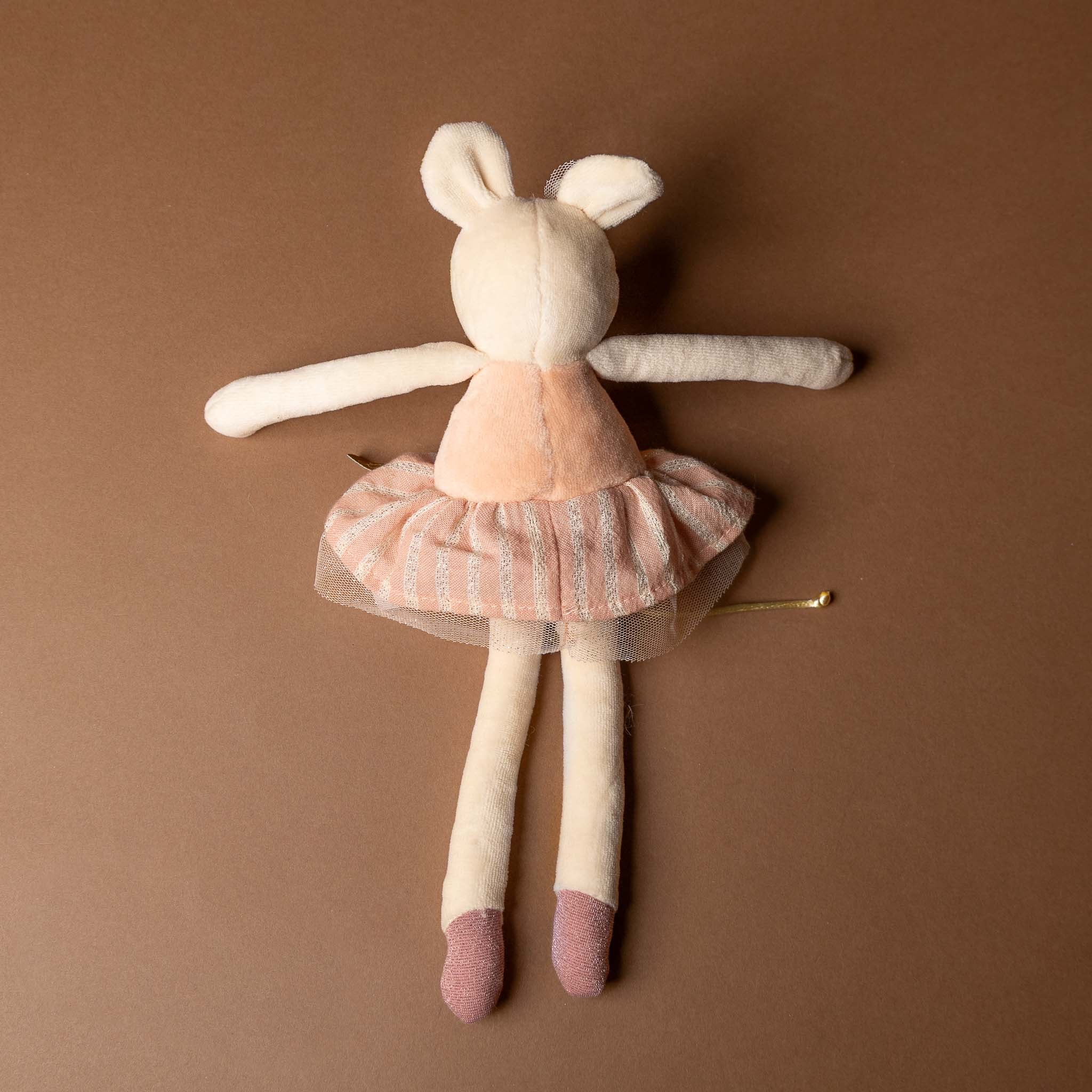 dance-mouse-rose Plush toy rabbit in a pink dress on a brown background