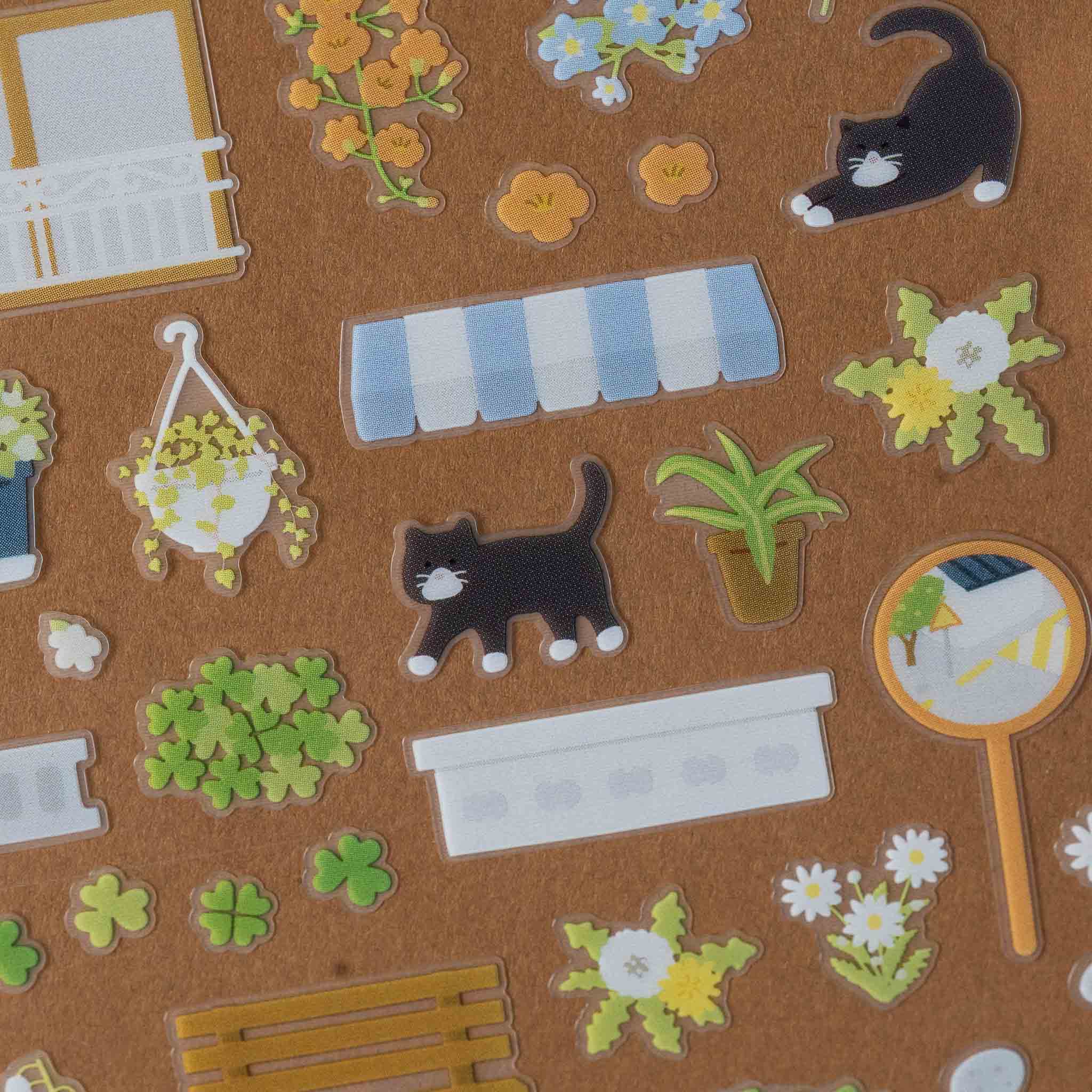 Collection of decorative deco-sticker-sheet-curb-appeal with cats, flowers, and other elements on a brown background