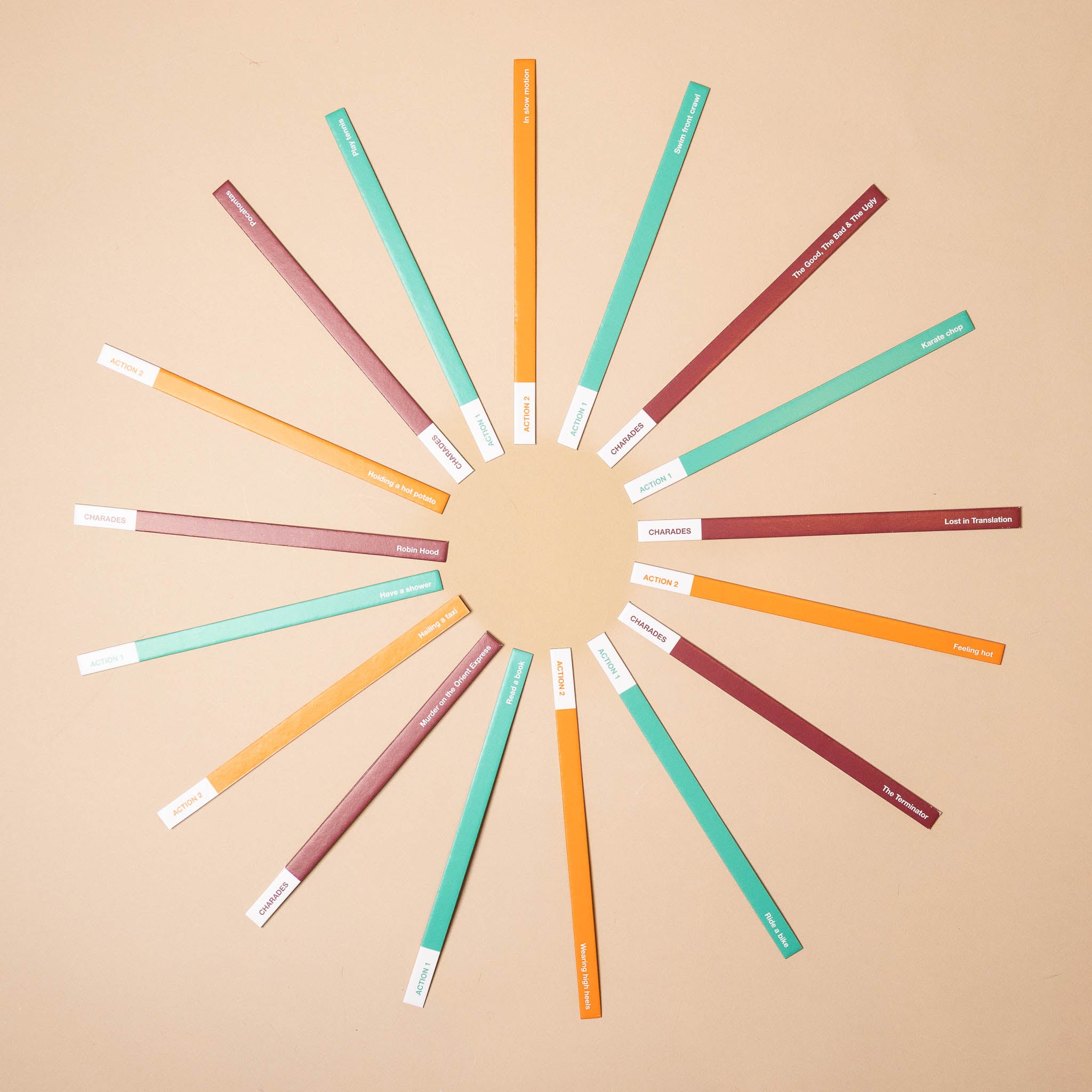 dipstick-game-crazy-charades Set of colorful sticks arranged in a circular pattern on a beige background