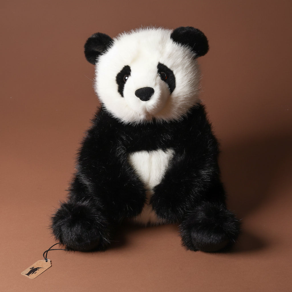 Plush emmet-the-panda-bear toy on a brown background