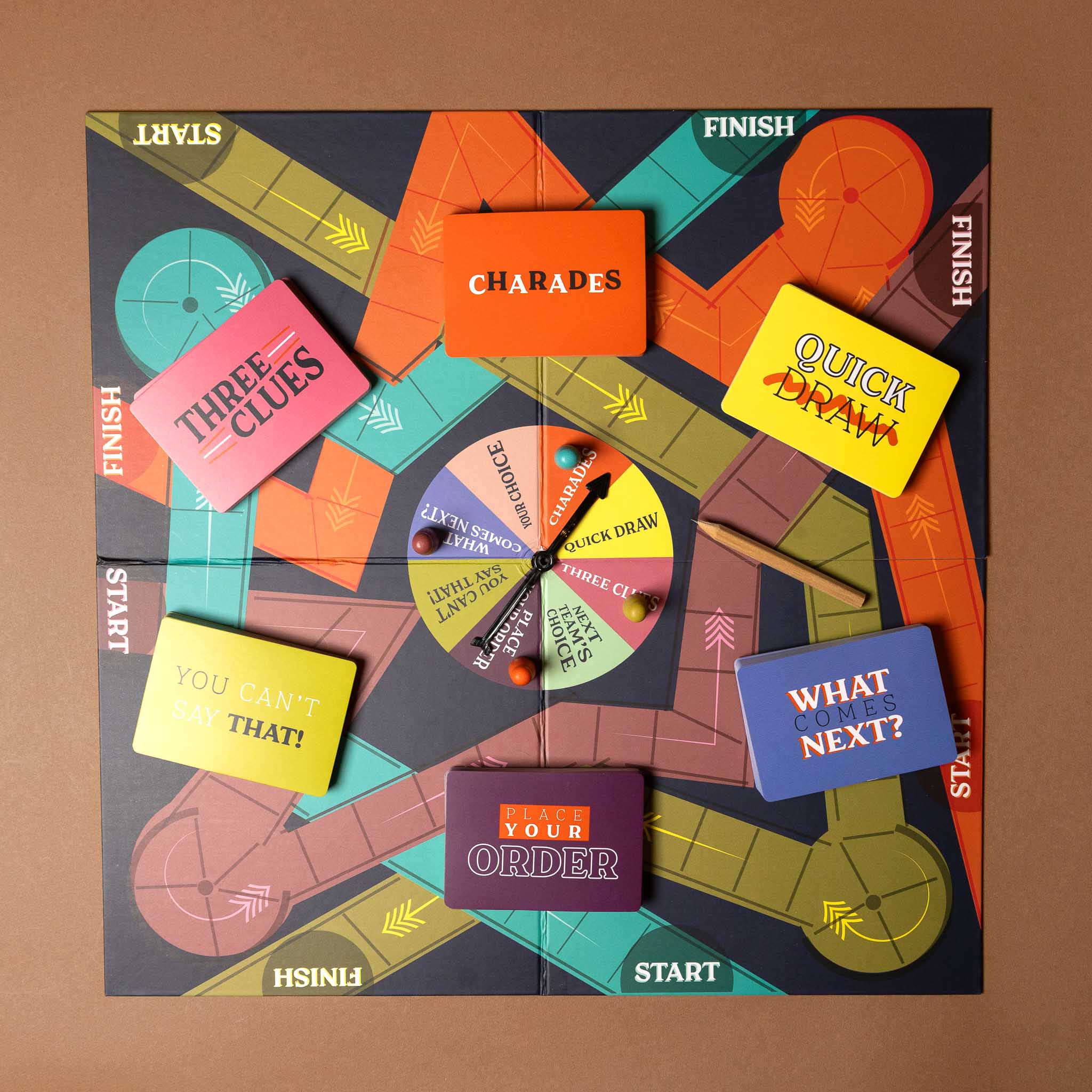 friends-and-family-games-night Board game packaging with various cards and a spinner on a brown background