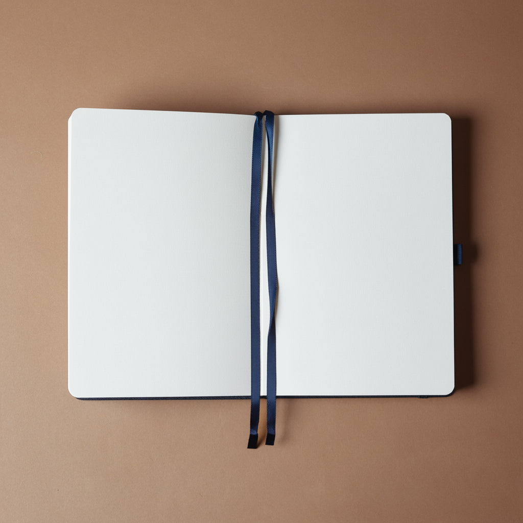 Open notebook with a navy cover on a brown background