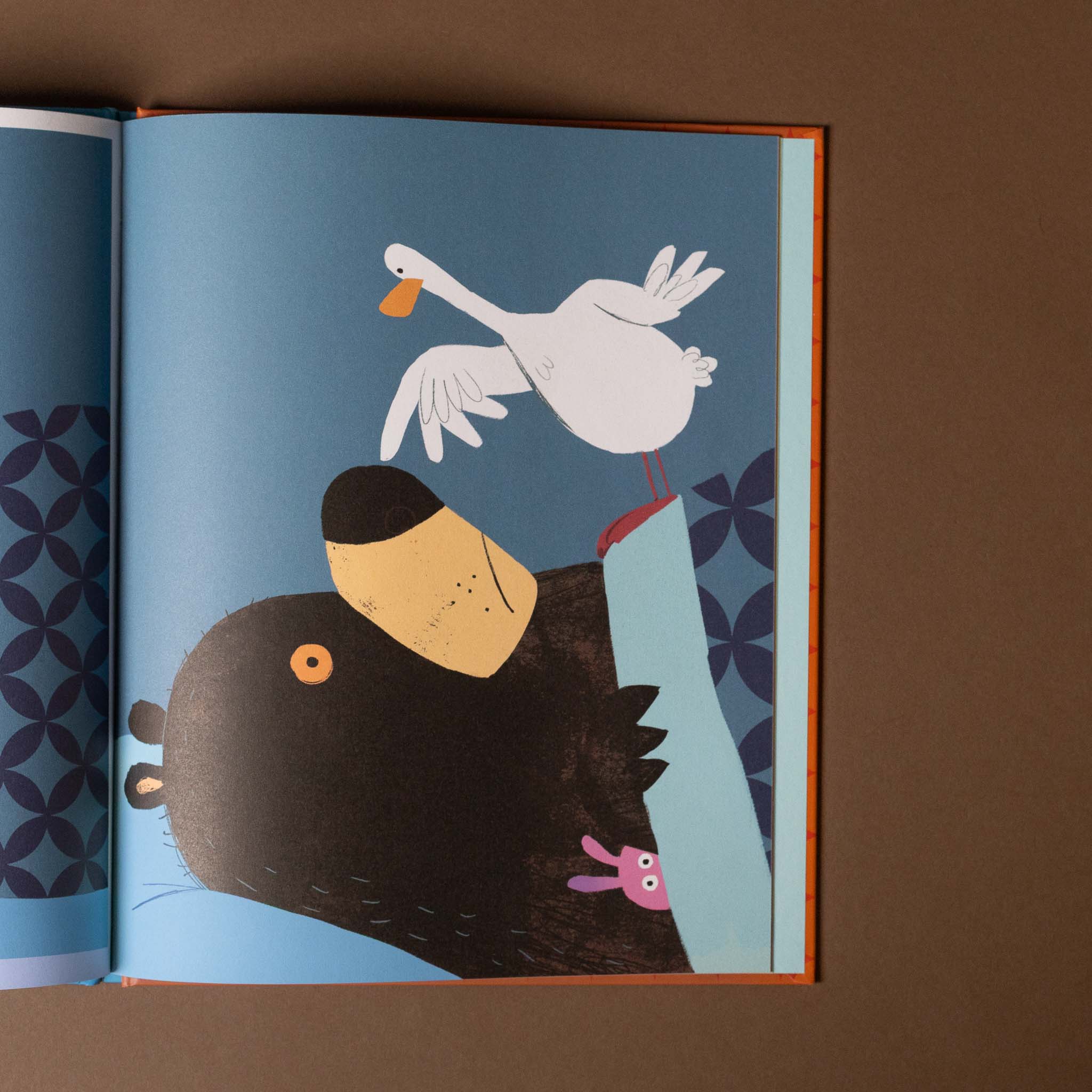 Illustration of a swan and a bear in a book on a brown background
