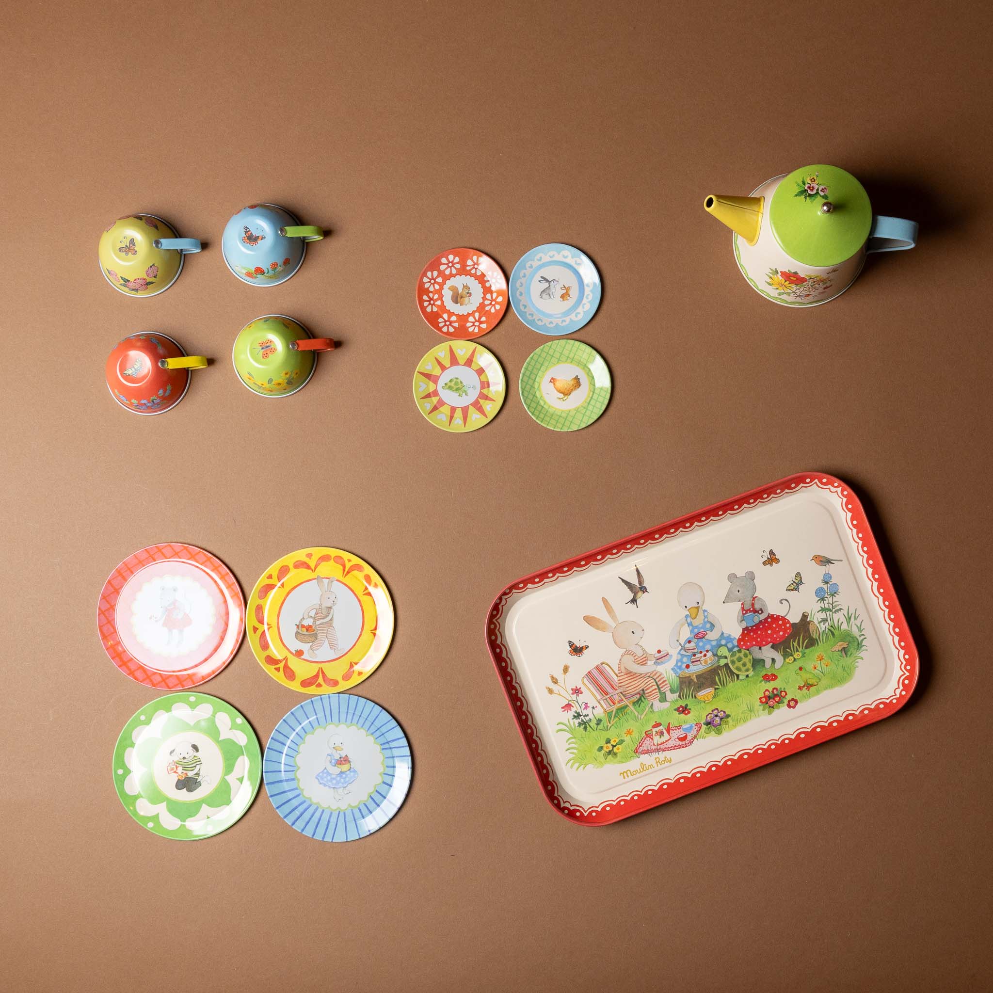 grande-famille-tea-set Colorful children's tea set with teacups, saucers, and a tray on a brown background