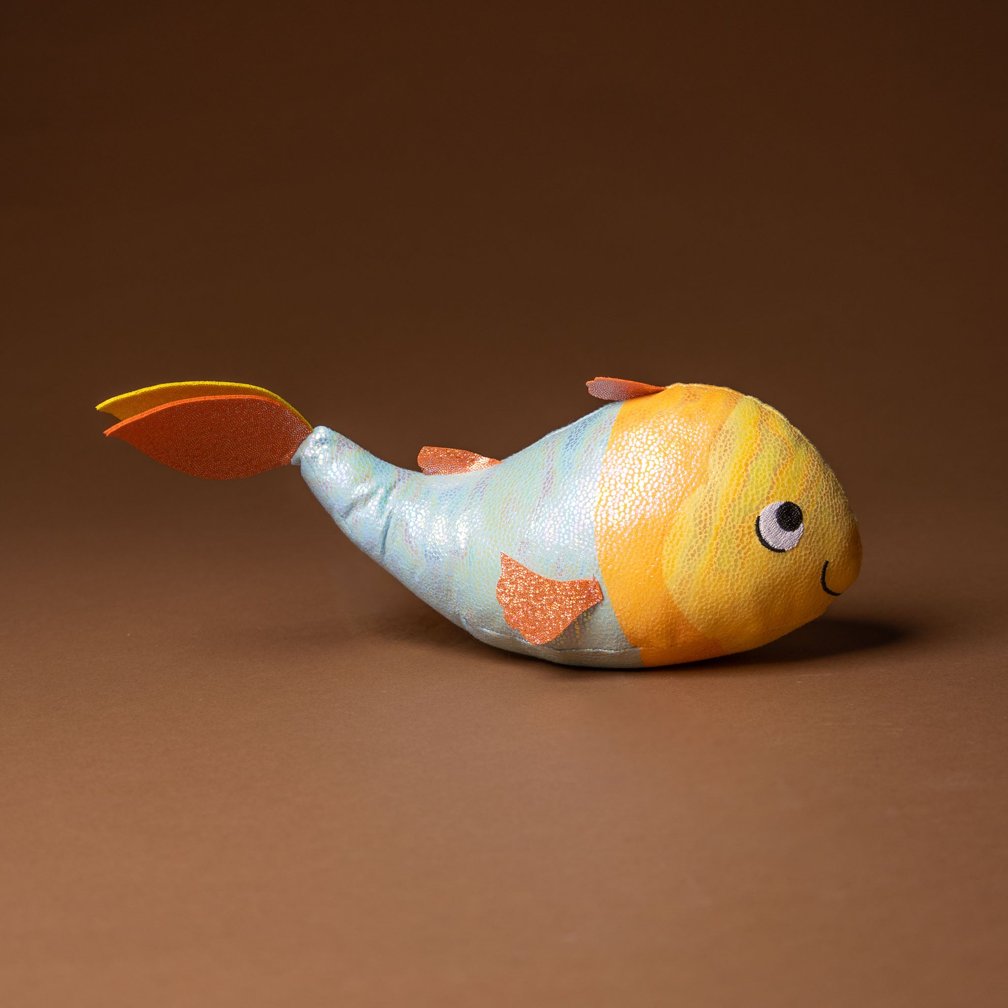 gus-the-guppie-fish Colorful fish-shaped toy on a brown background
