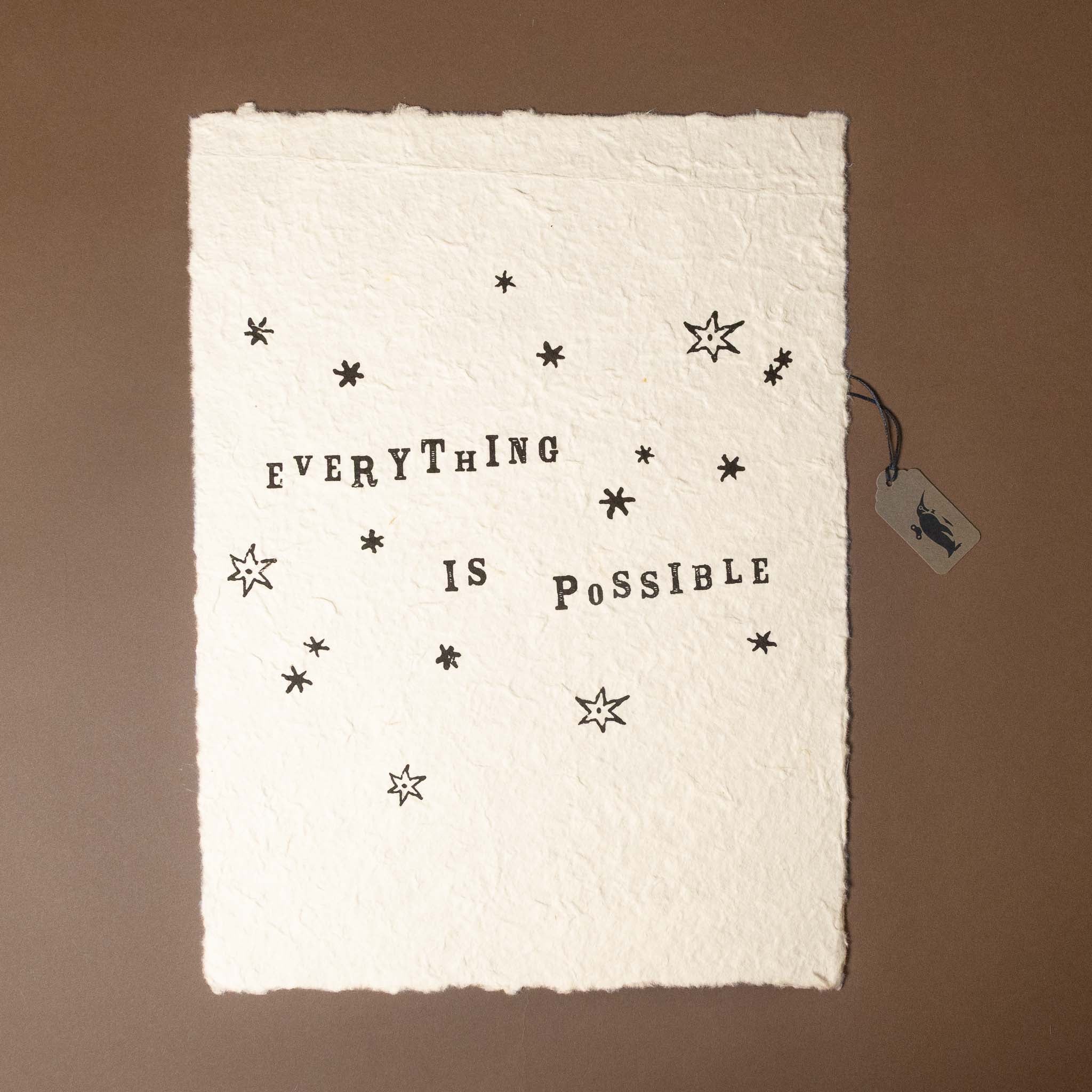Textile with 'Everything is Possible' text and star patterns on a brown background