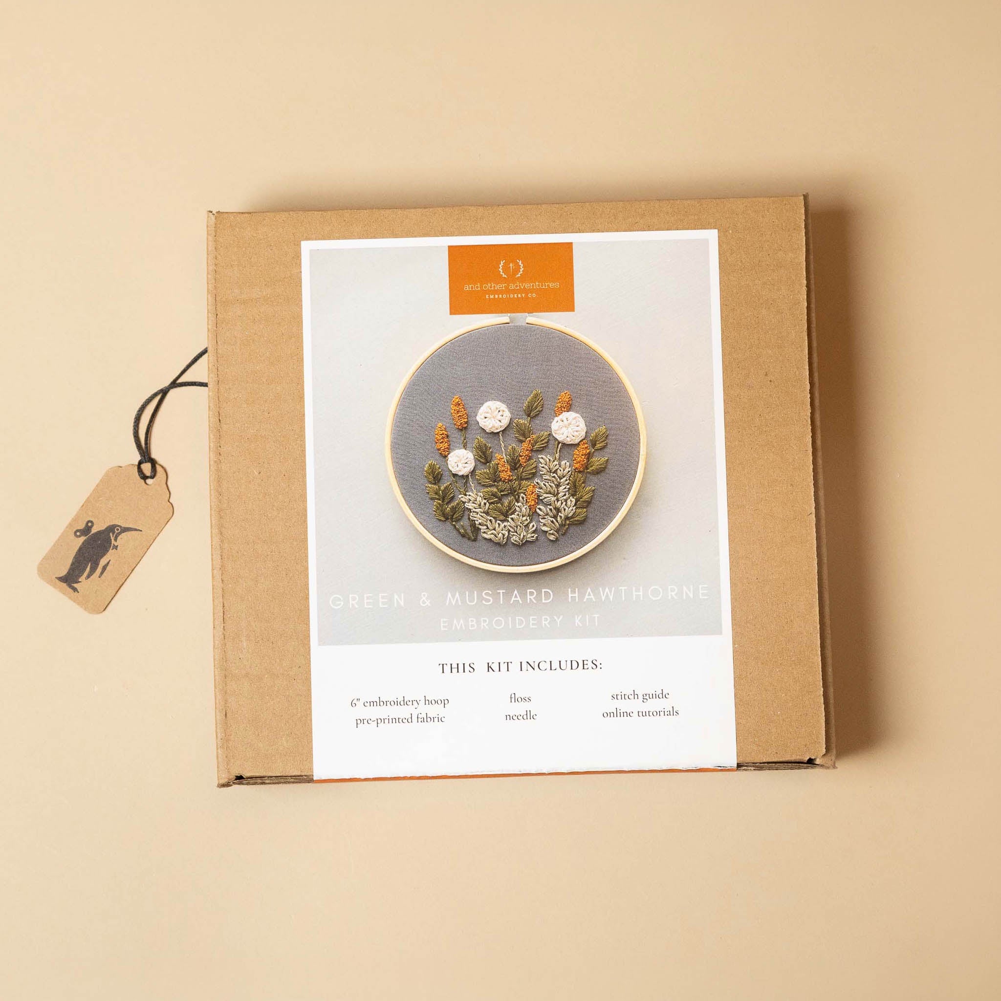 hawthorne-embroidery-kit-green-and-mustardpackaging with a floral design on a beige background