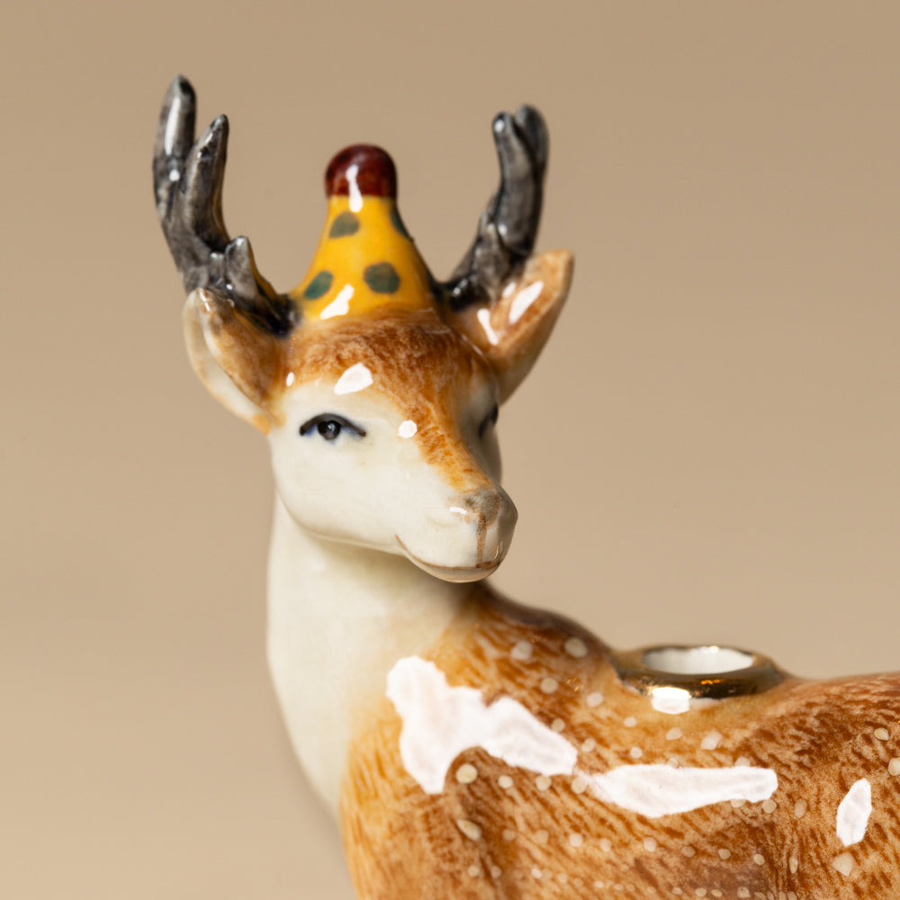 heirloom-porcelain-cake-topper-stag Deer figurine with a party hat on a beige background