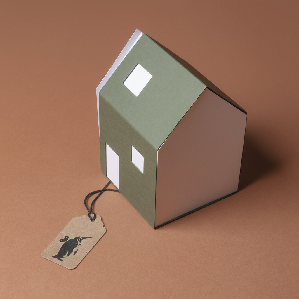 Green paper house with a tag on a brown background