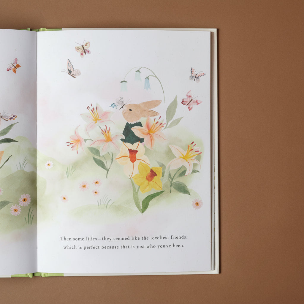 Open book with a colorful illustration of a rabbit among flowers and butterflies on a brown background.