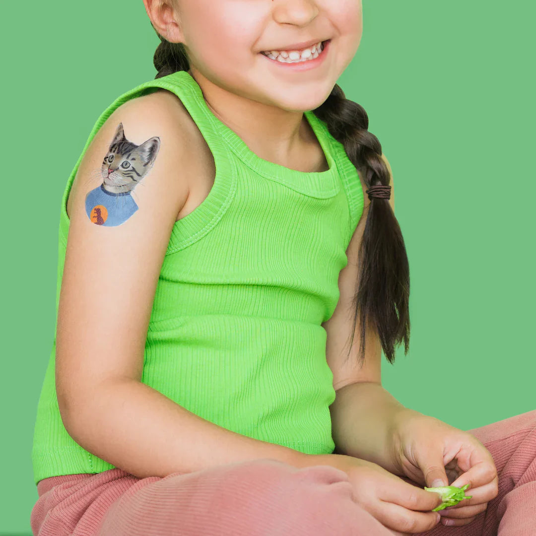 Child with a jumbo-temporary-tattoo-party-pack-creature-collective of a cat on a green background