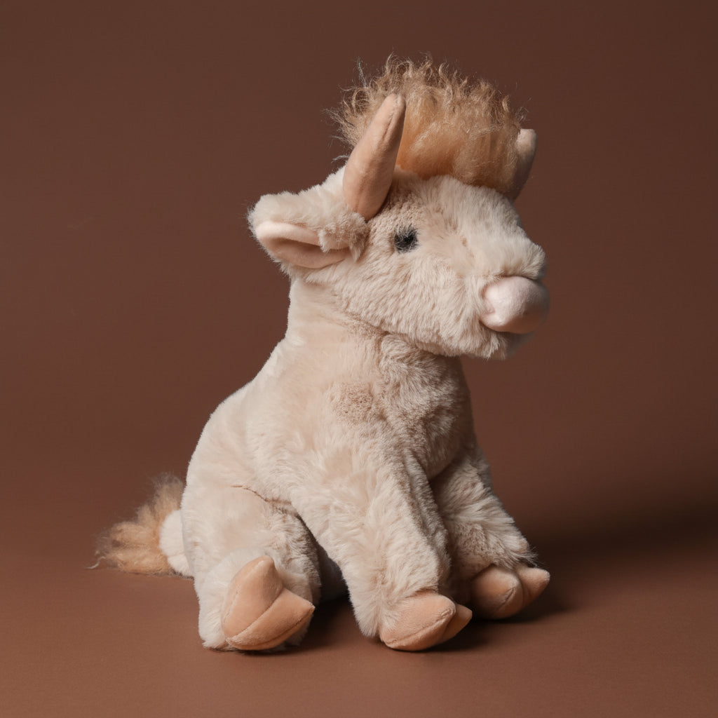 Plush toy lad-the-highland-cow on a brown background