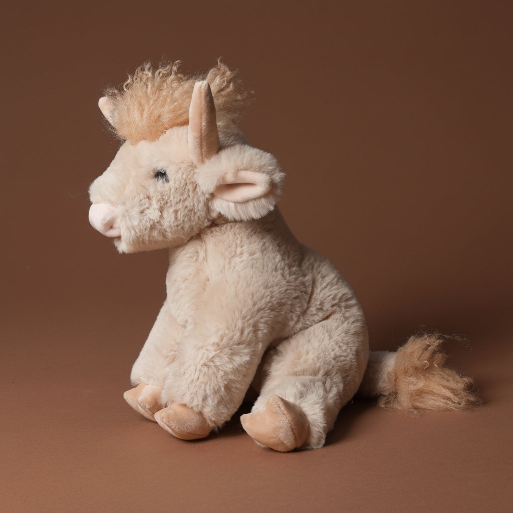 Plush toy lad-the-highland-cow on a brown background