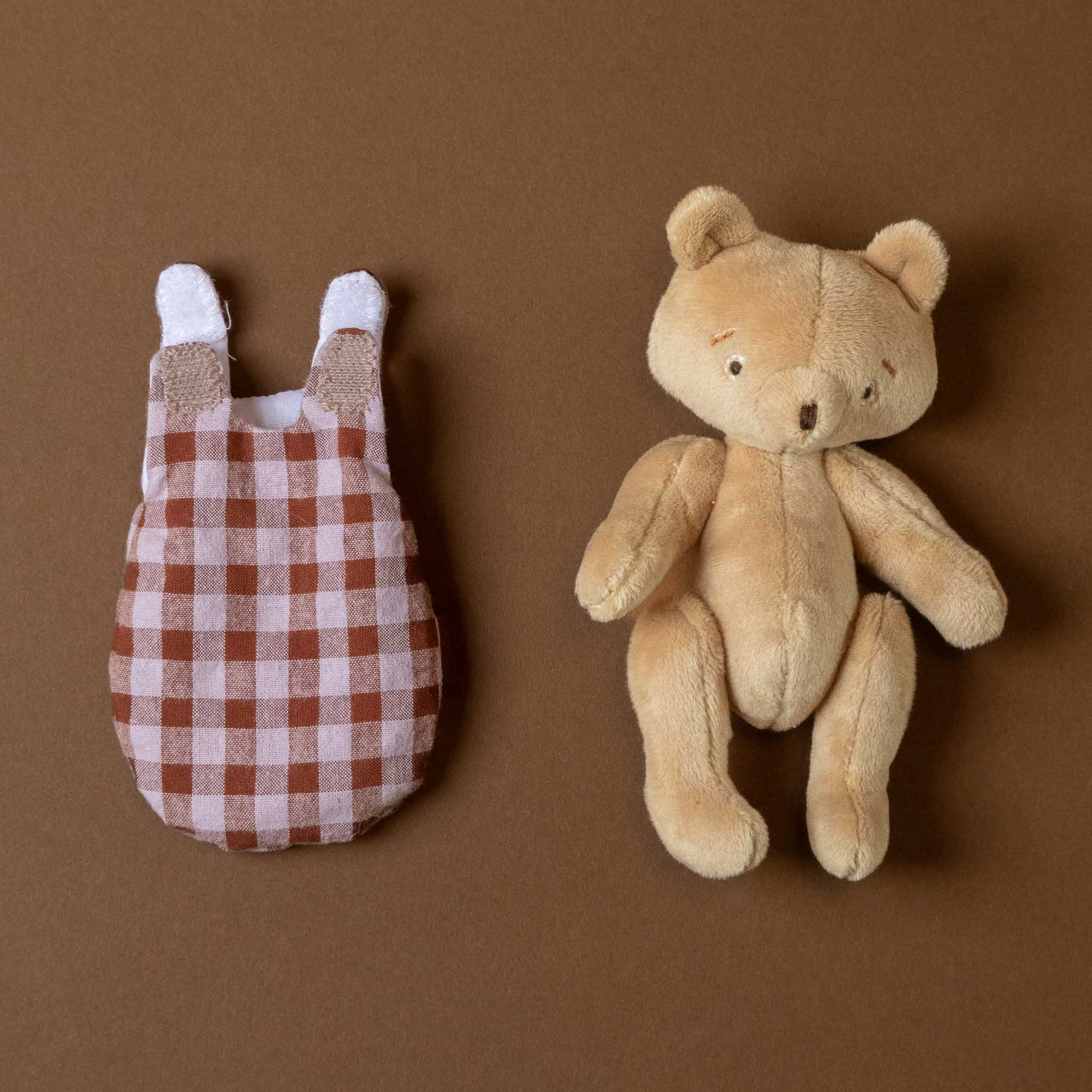 les-minouchkas-bebe-emile-the-bear Plush toy bear and checkered outfit on a brown background