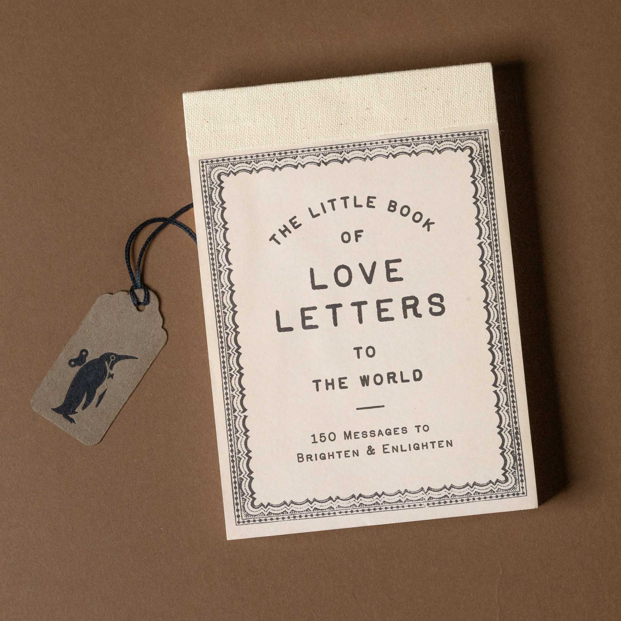 Book titled 'The Little Book of Love Letters to the World' with a tag on a brown background