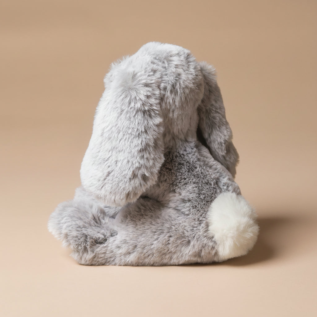 Gray plush little-lottie-bunny-grey toy on a beige background