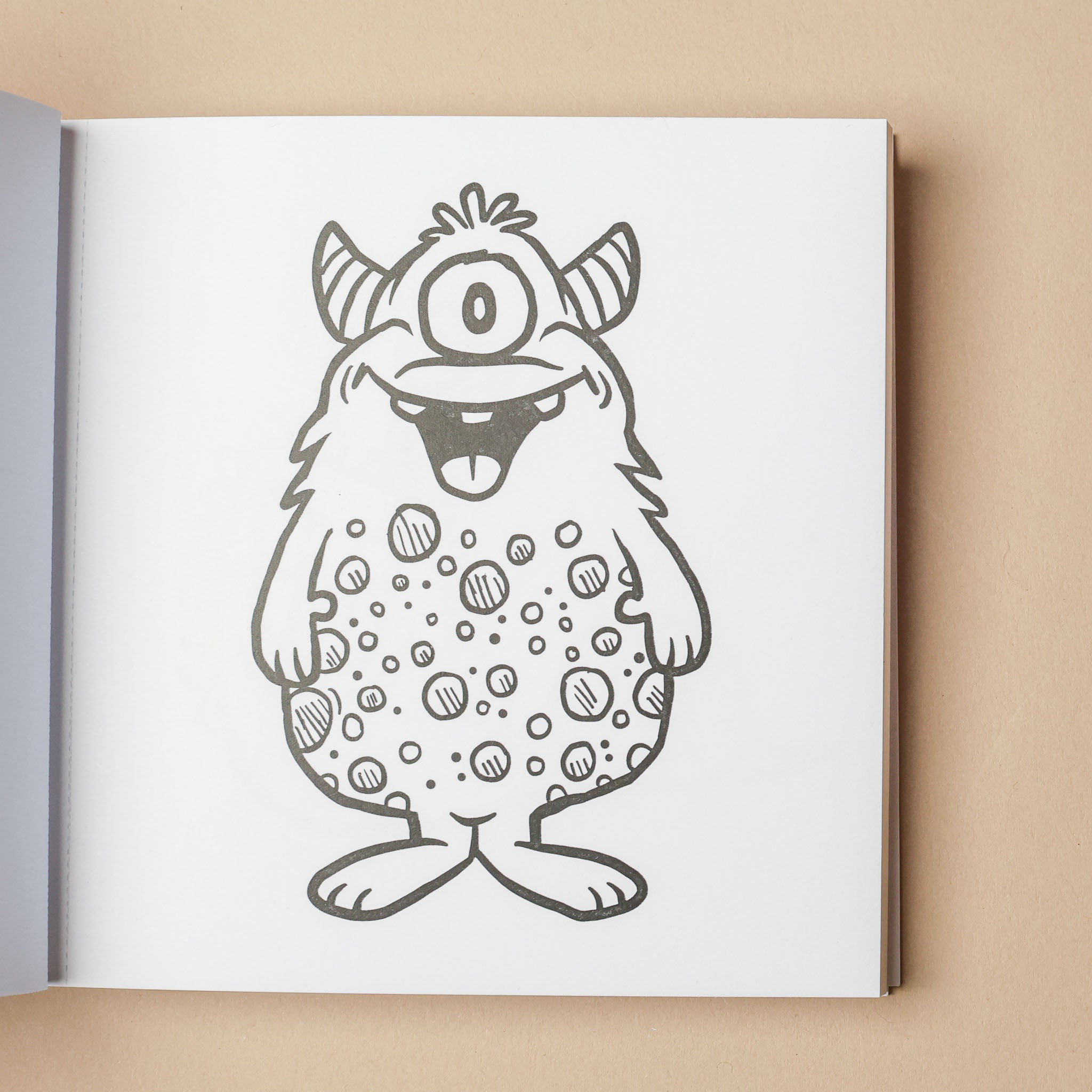 Coloring book page with a cartoon monster drawing on a beige background