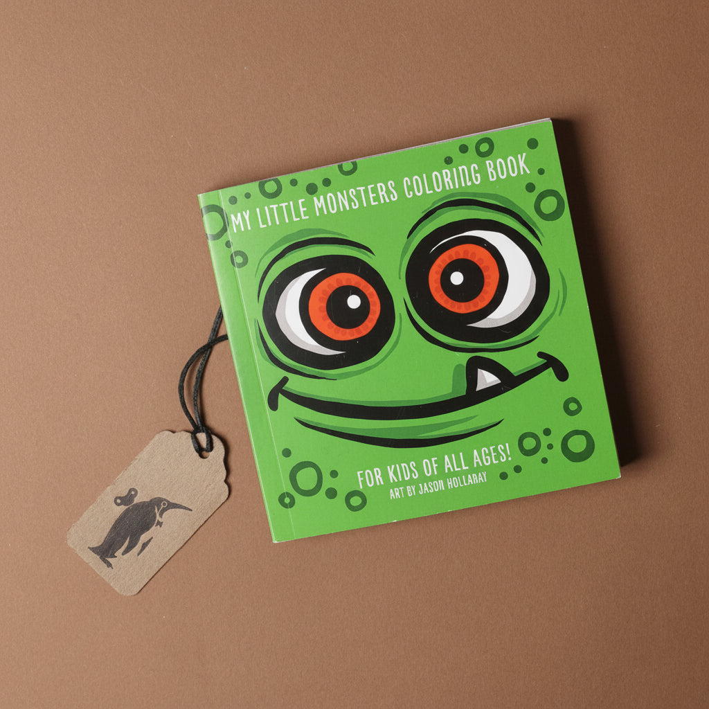 Green coloring book with monster face design on a brown background