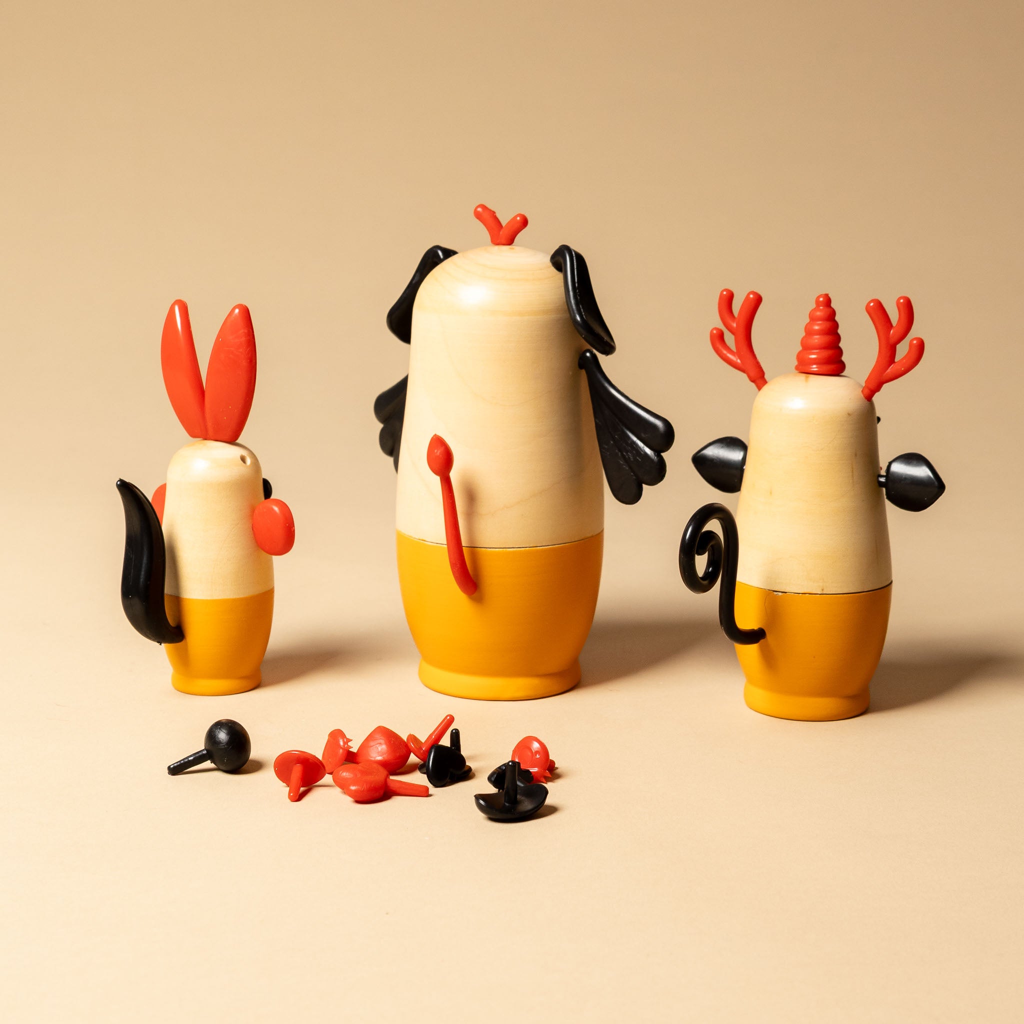 make-your-own-nesting-yoshka-animals Three colorful animal figurines with detachable parts on a beige background