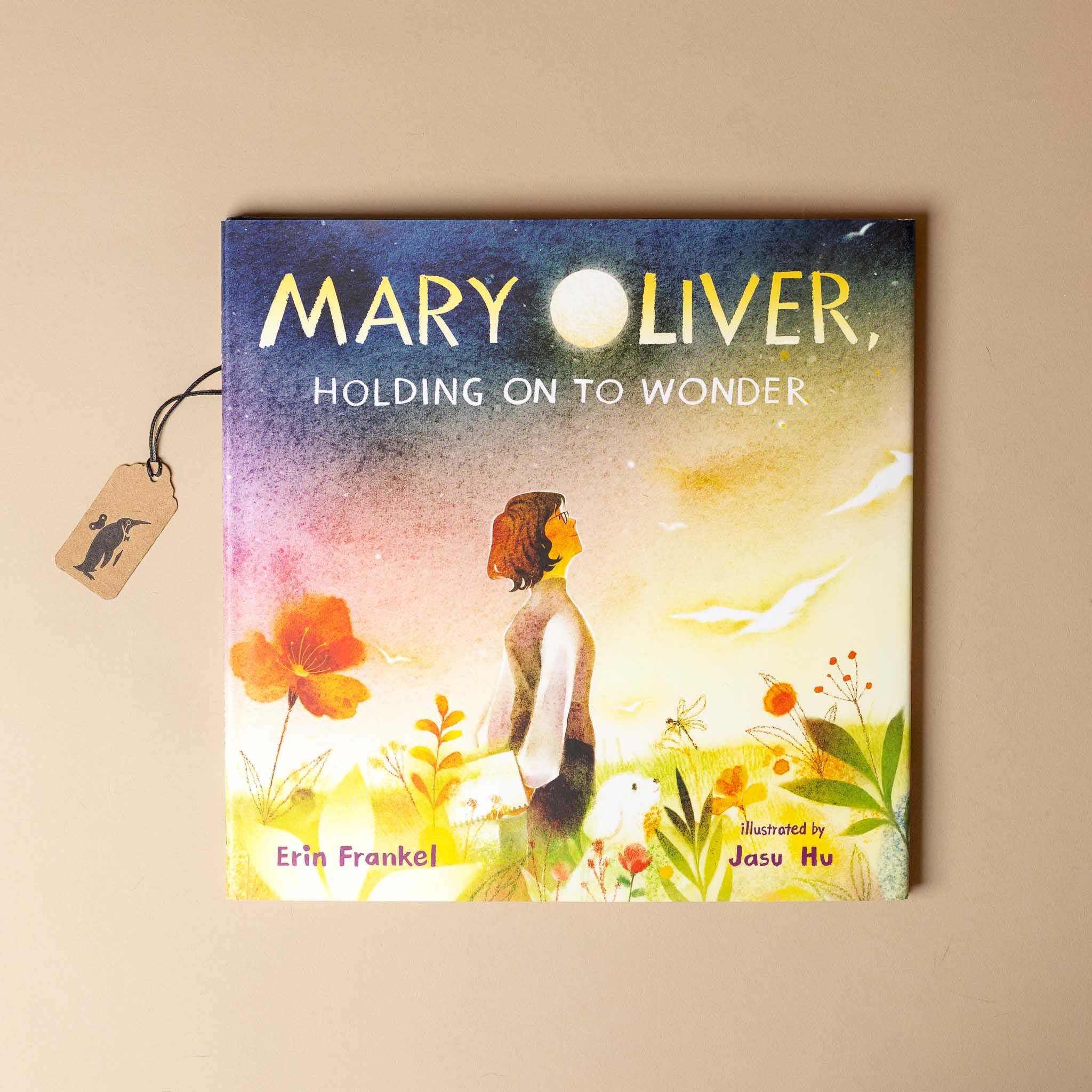 Book cover of 'Holding on to Wonder' by Mary Oliver with a tag and beige background