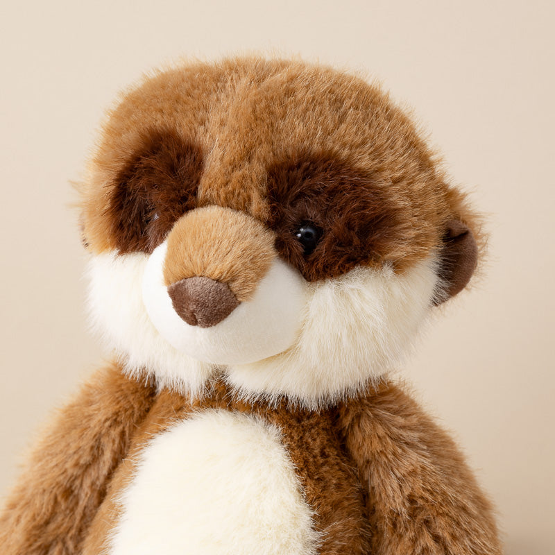 A close-up of a plush stuffed animal with brown and white fur, resembling a beaver or nutria, photographed against a plain beige background.