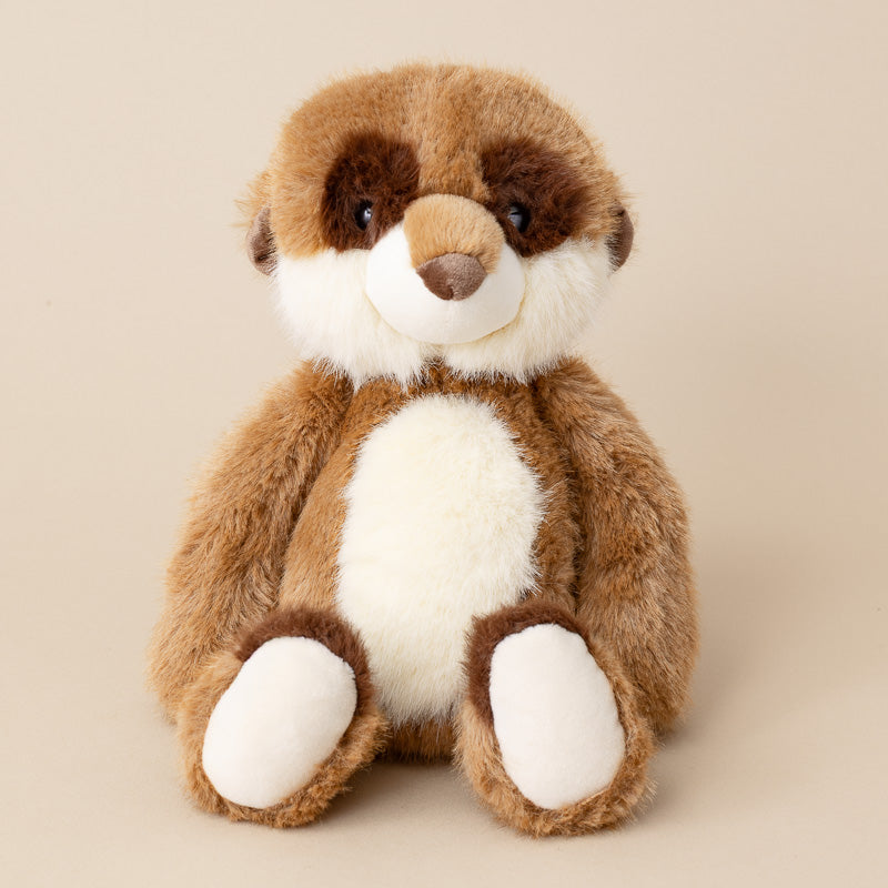 A plush toy raccoon sitting upright against a solid beige background. The toy features brown and white faux fur with embroidered black eyes and a brown stitched snout.