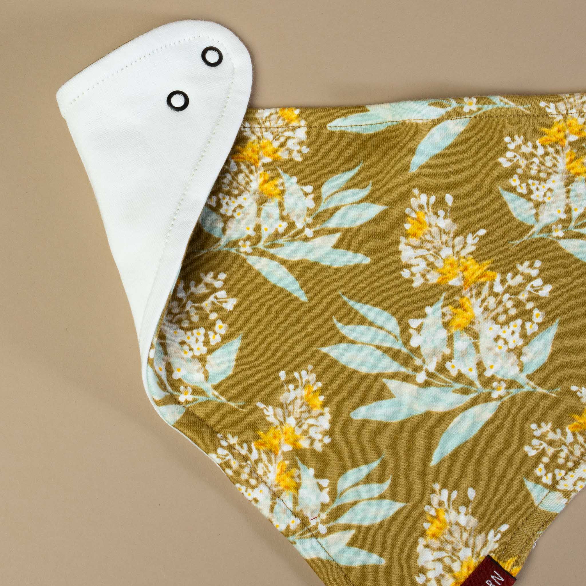 detail-showing-snaps-and-floral-print-on-gold-background