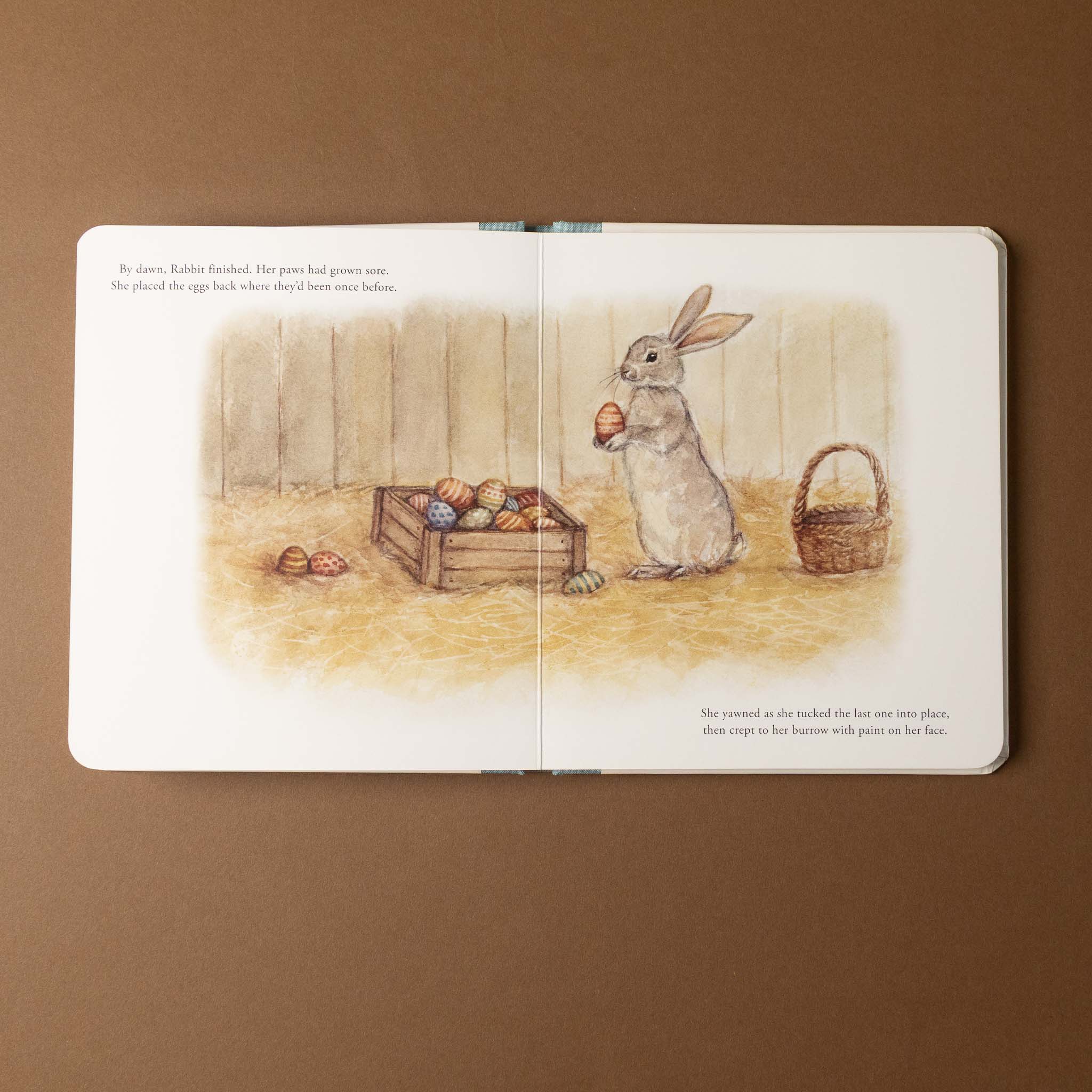 Illustrated our-little-adventures-at-easter-board-book open to a page with a rabbit holding an egg on a brown background