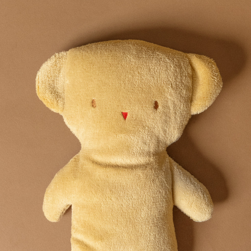 pancake-teddy bear stuffed-animal with a tag on a brown background