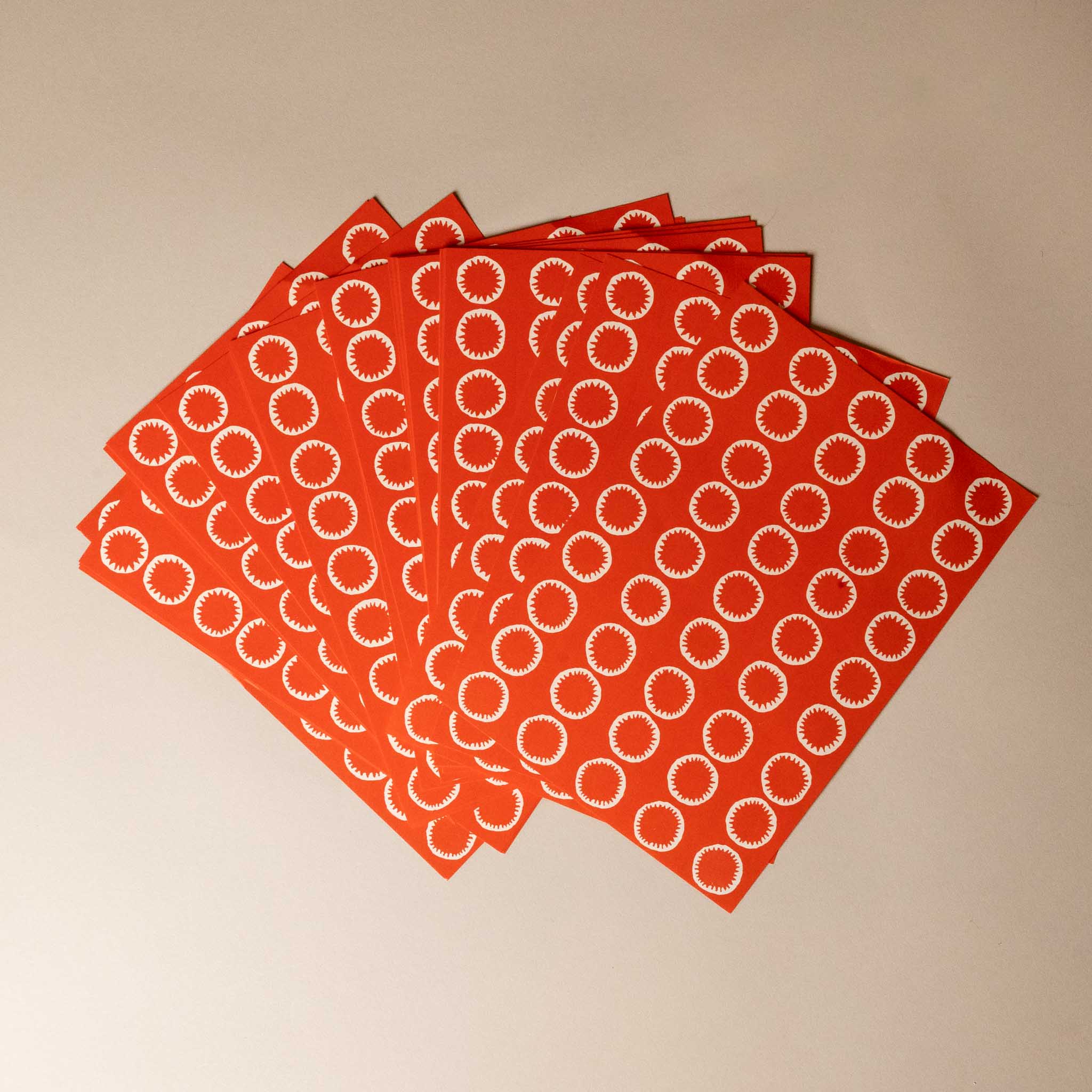 paperchain-set--red-red-white-Red paper with white circular patterns on a beige background
