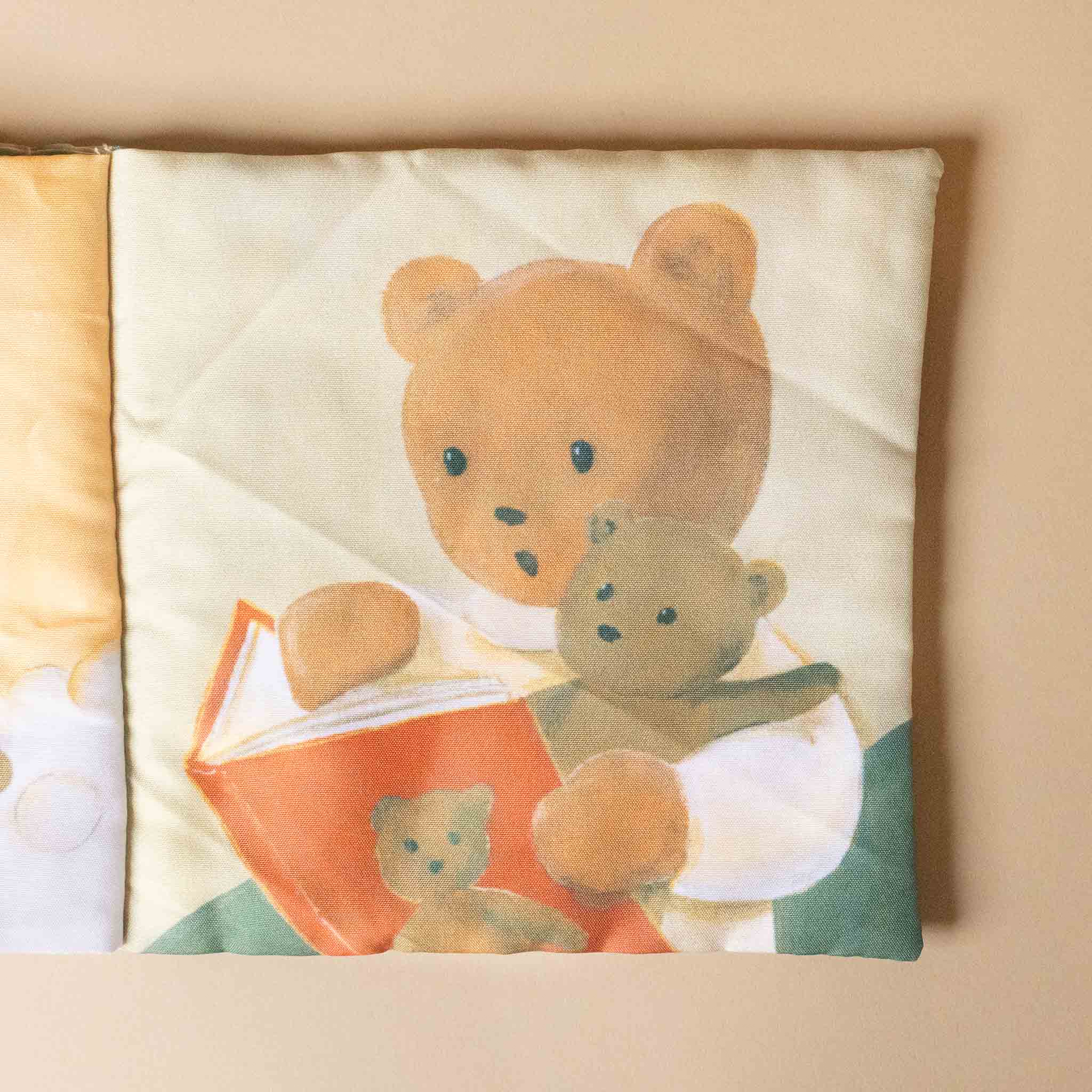 petite-fabric-book-marcel-the-bearn with teddy bear design reading a book to another teddy bear on a beige background