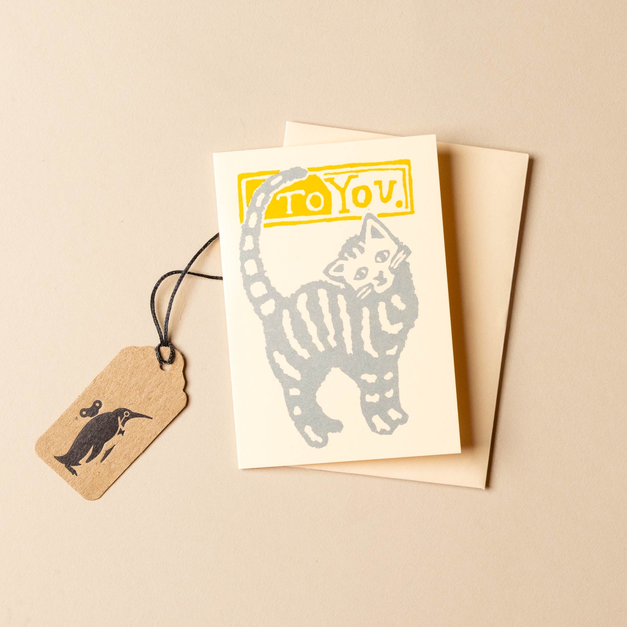 petite-kitten-greeting-card with cat illustration and 'To You' text, accompanied by a tag on a beige background