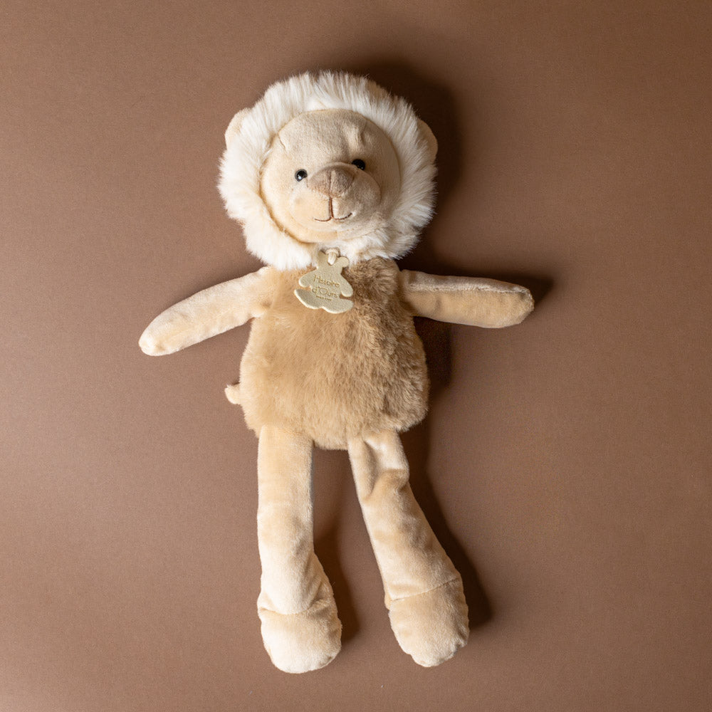 petite-lion-cub Stuffed animal toy with a fur coat and hat on a brown background