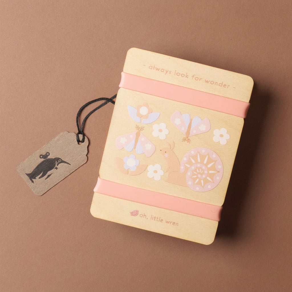 petite-wooden-flower-press-squirrel with decorative elements and a pink ribbon on a brown background