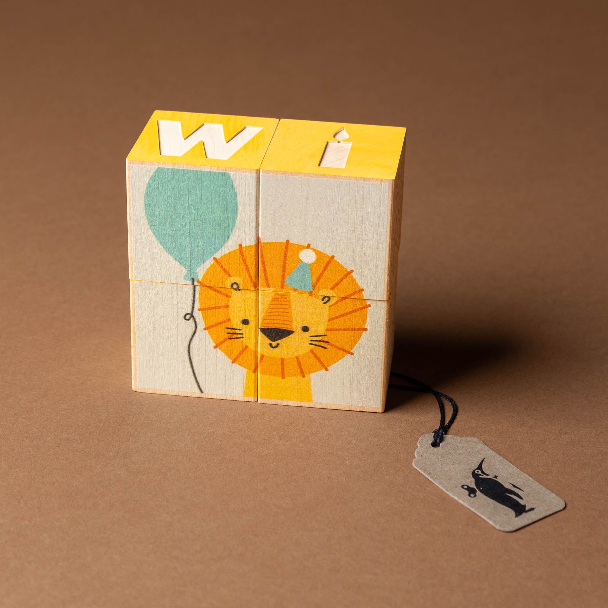 petite-wooden-gifting-block-set-wish Wooden block with lion design and letter 'W' on a brown background