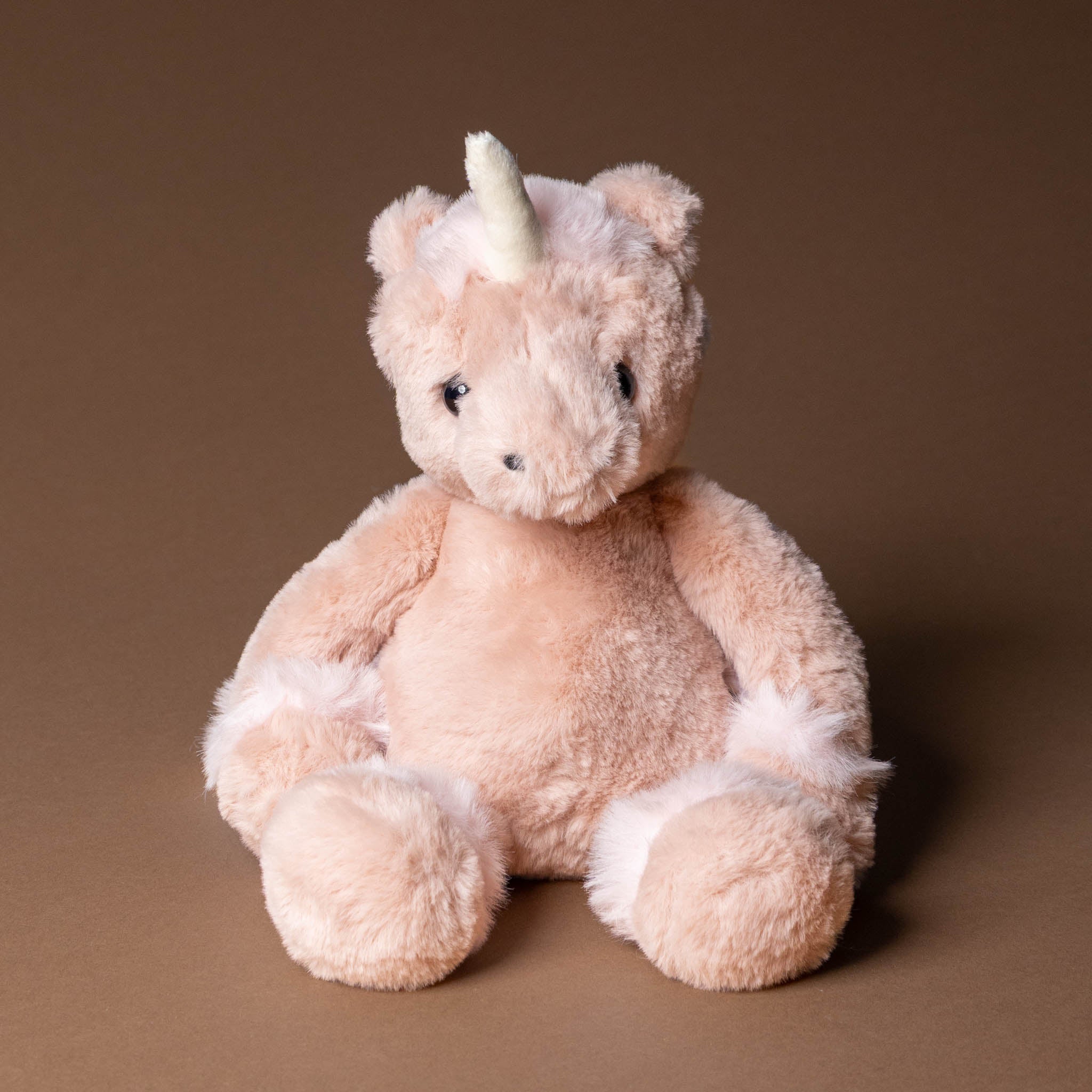 pirouette-the-unicorn Plush unicorn toy on a brown background
